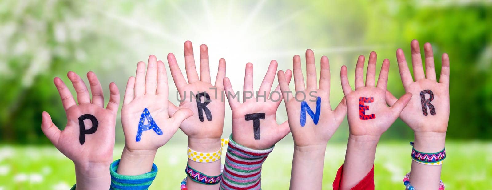 Children Hands Building Colorful English Word Partner. Summer, Sunny Green Grass Meadow As Background