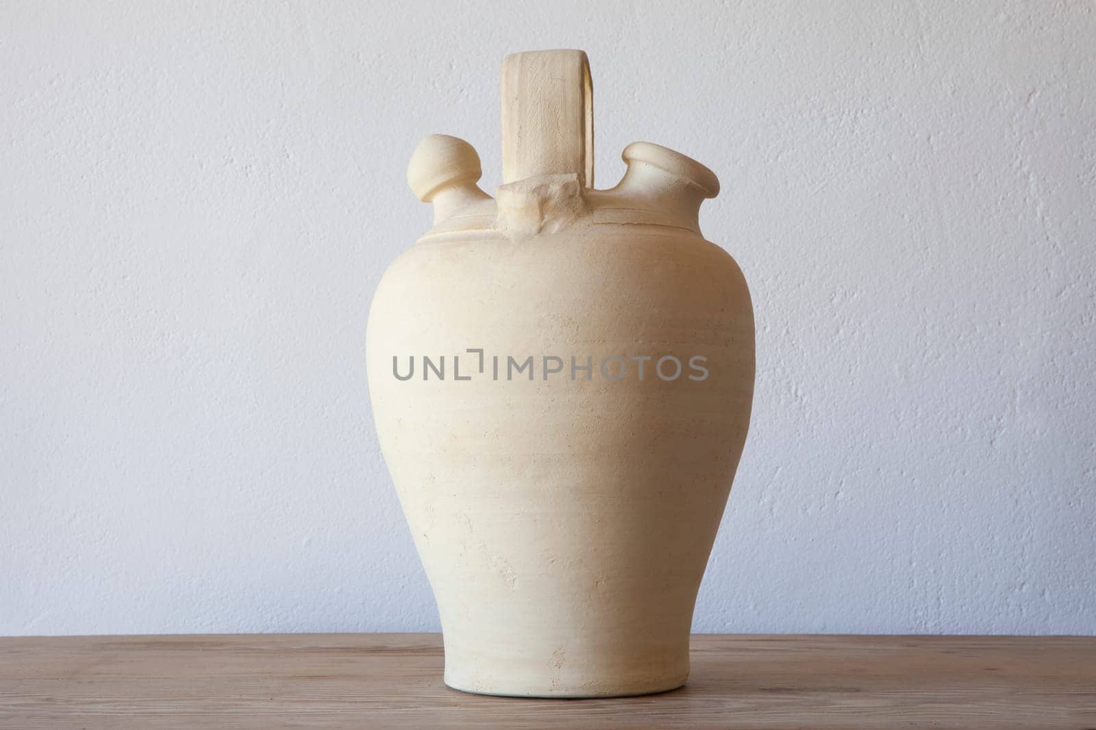 White earthenware botijo, traditional clay pot jug to keep fresh water. Selective focus
