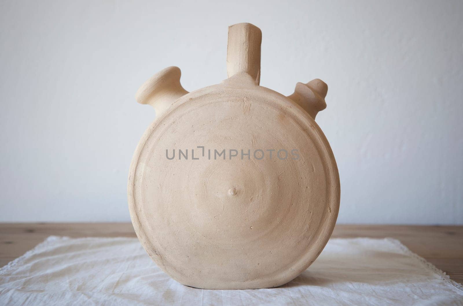 White earthenware botijo, traditional clay pot jug to keep fresh water. Circular shape