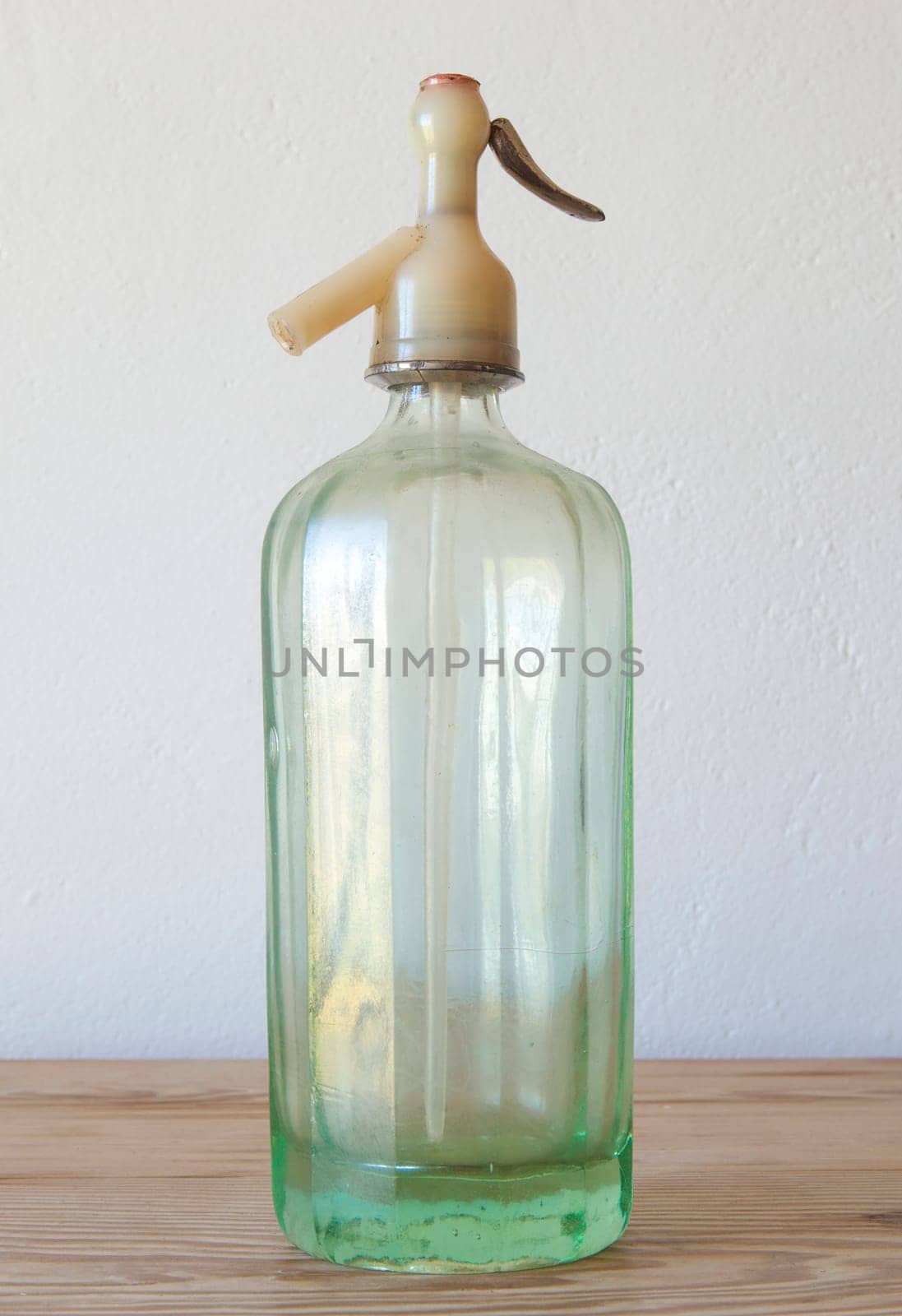 Old glass soda siphon. Wooden surface