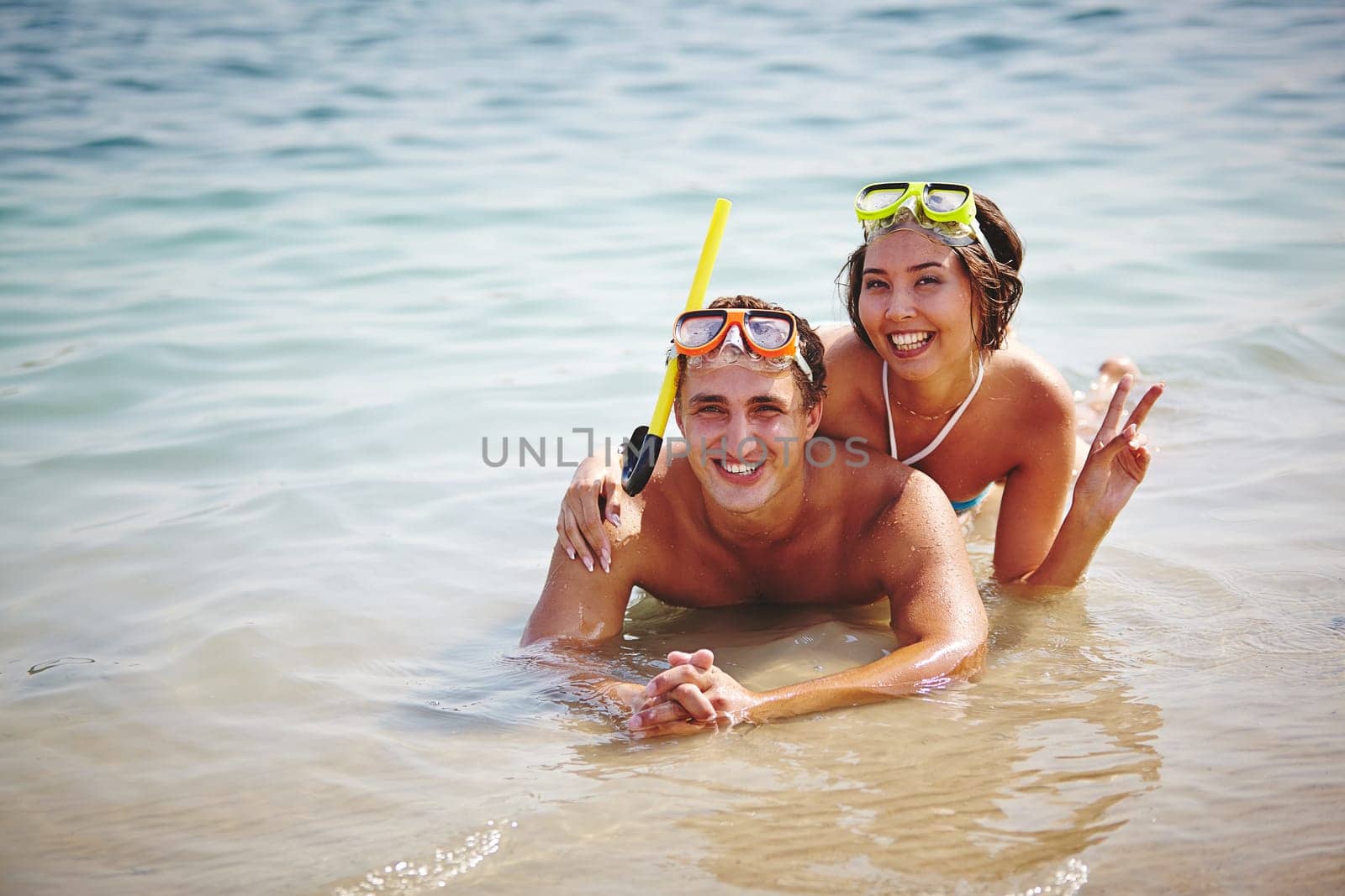Couple of happy scuba divers lying in water
