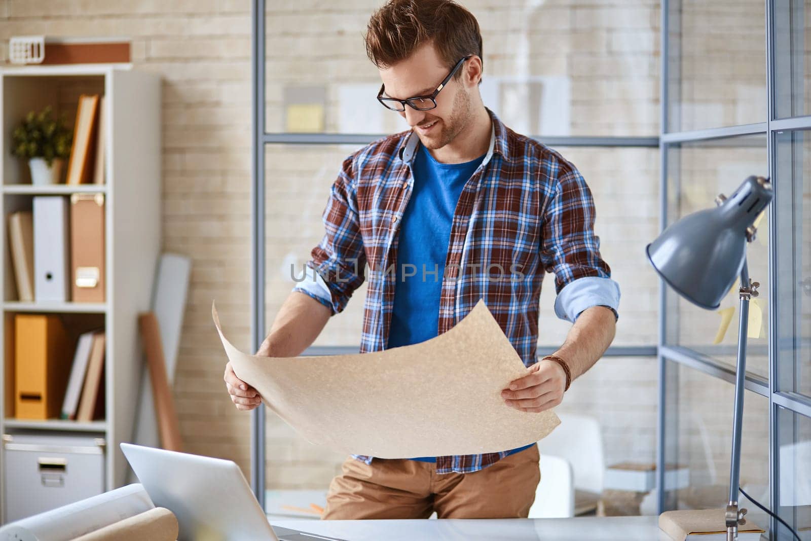 Handsome architect looking at sketch in his hands