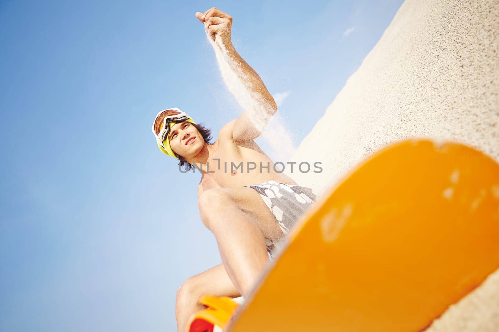 Handsome sandboarder enjoying summer vacation