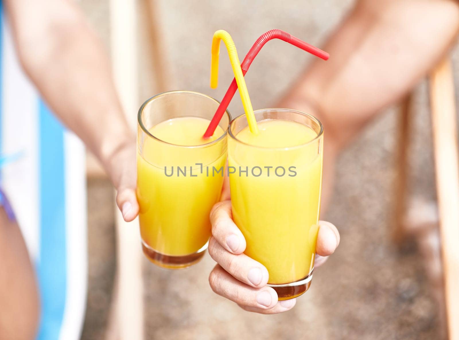 Glasses with orange juice held by couple