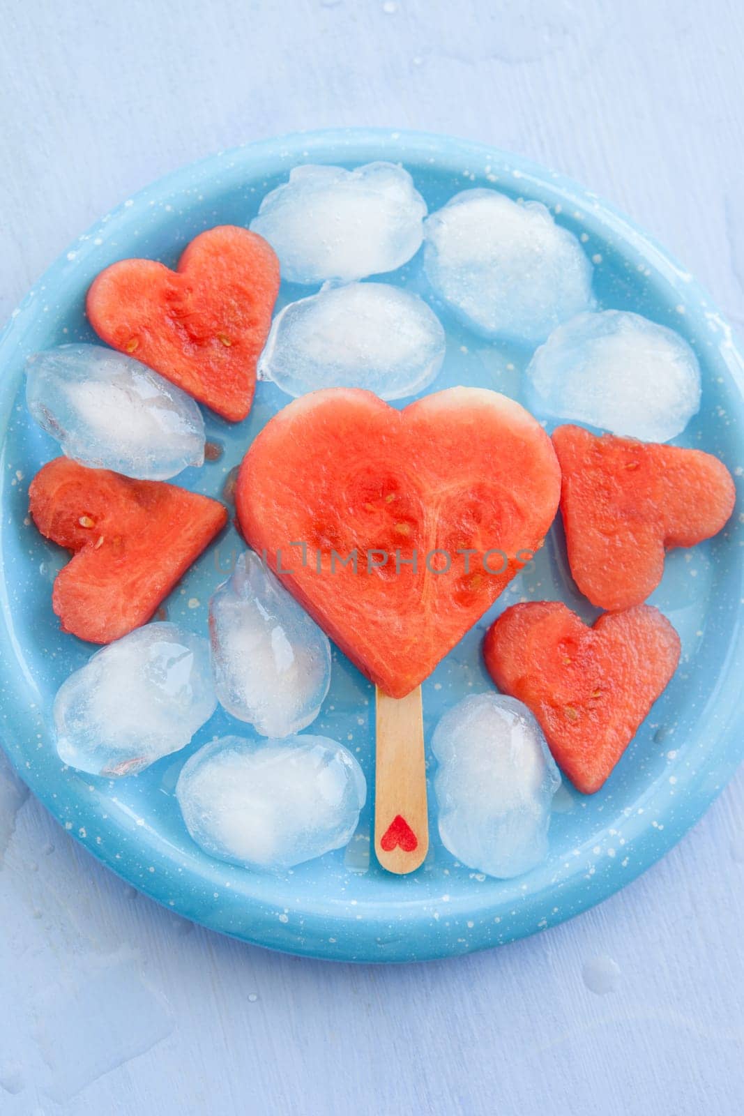 Cold watermelon in heart shape on a blue plate