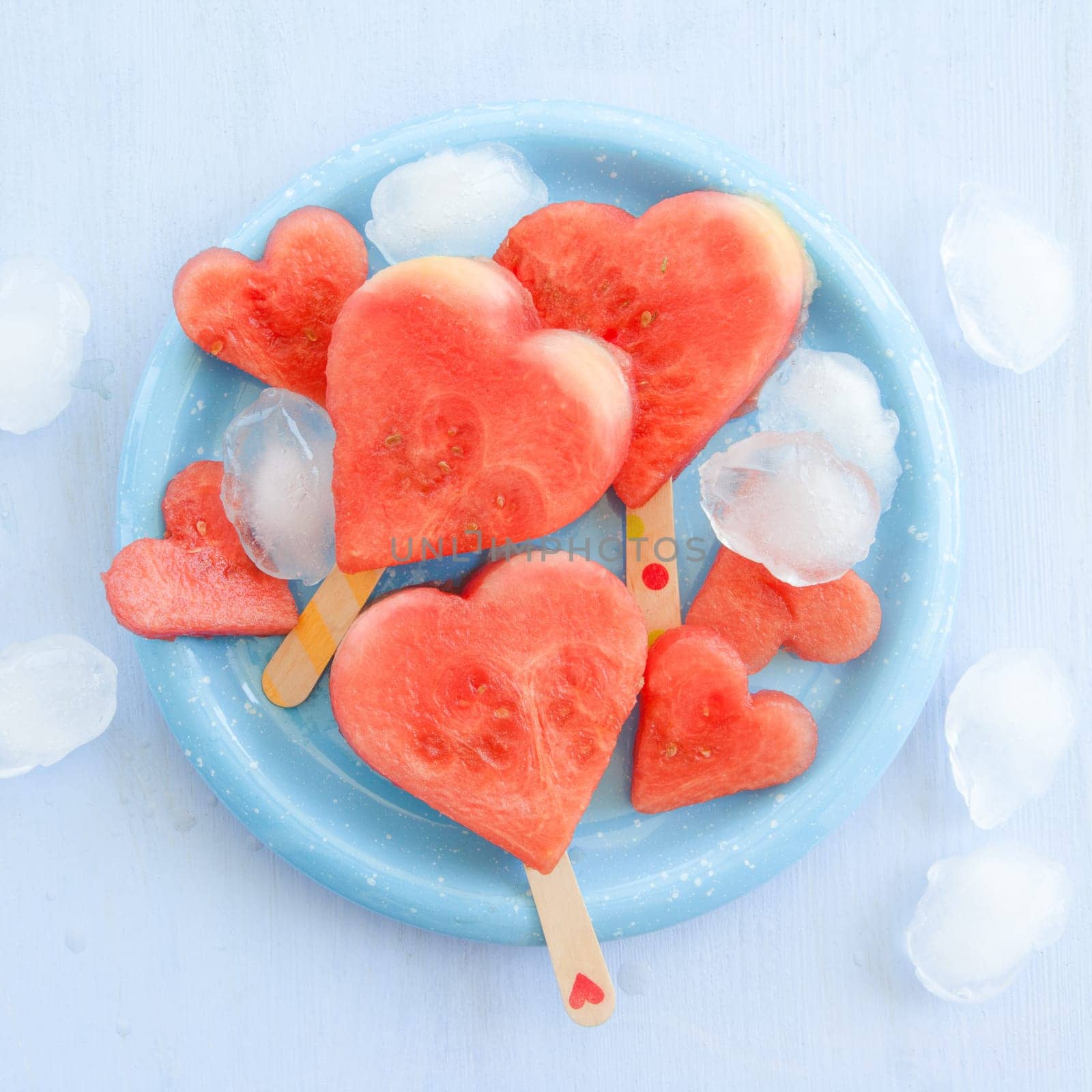 Cold watermelon in heart shape on a blue plate