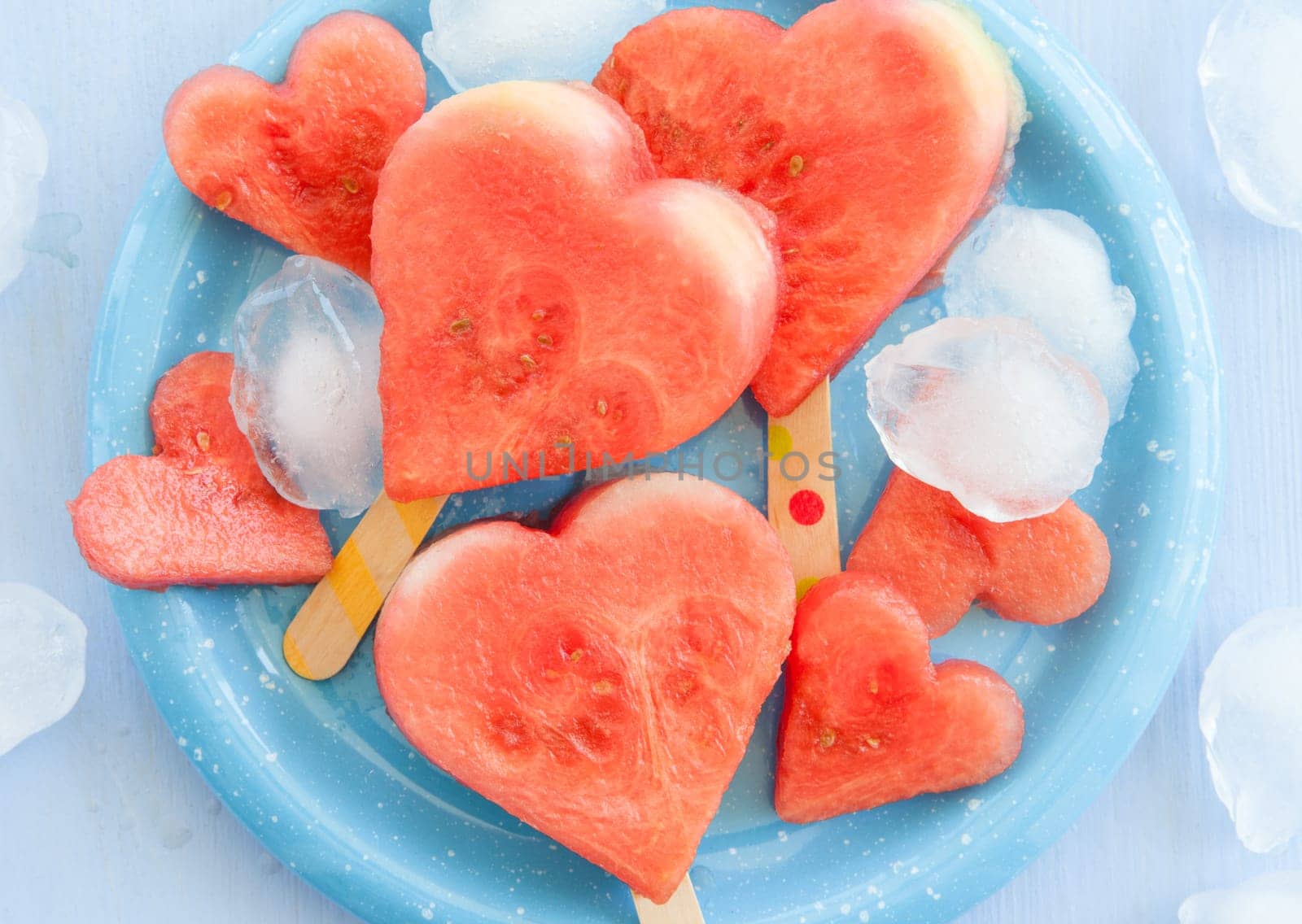 Cold watermelon in heart shape on a blue plate