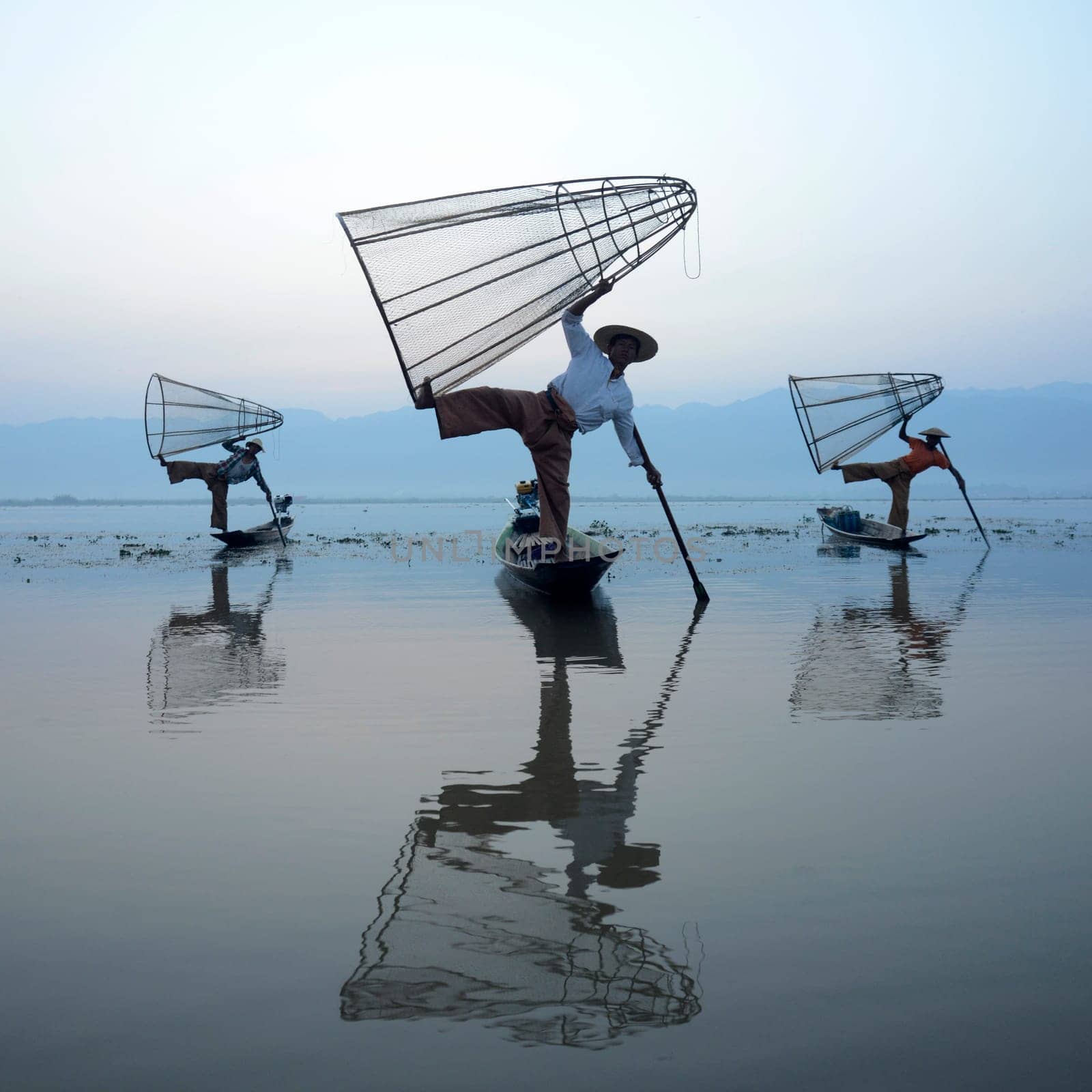 Fishermen at sunrise in the Landscape on the Inle Lake in the Shan State in the east of Myanmar in Southeastasia.