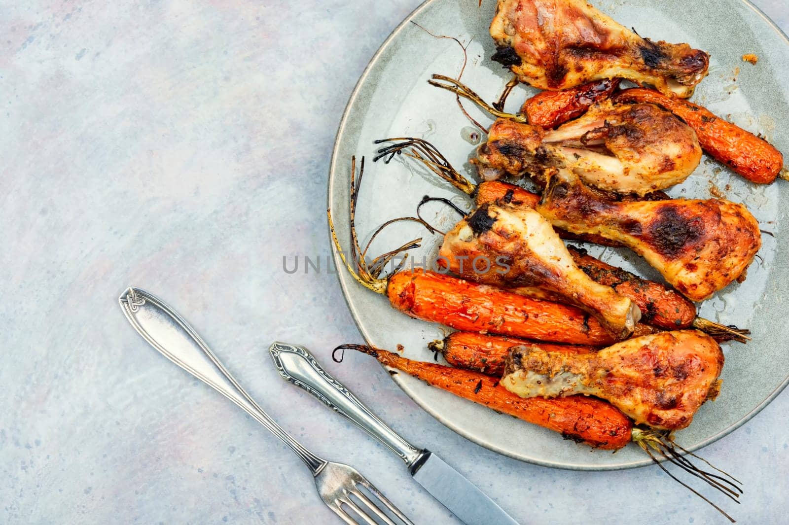 Appetizing chicken legs baked with vegetables. Homemade barbecue