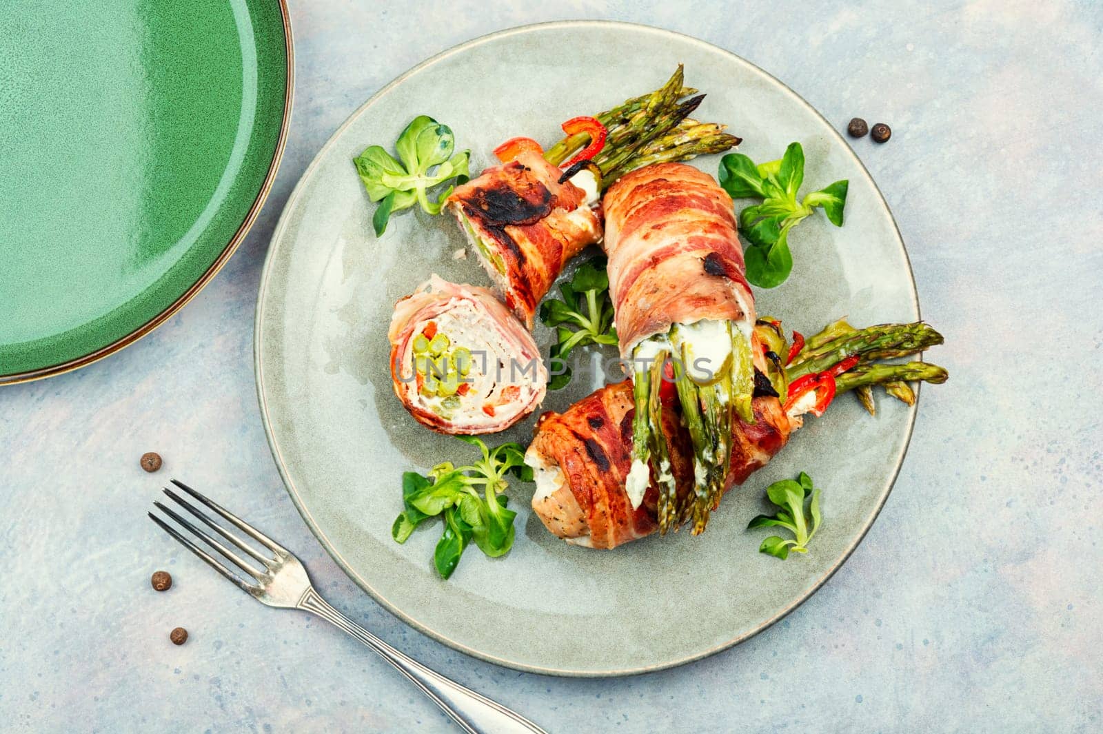 Beef roll wrapped in bacon. Meat stuffed with asparagus and cream cheese.