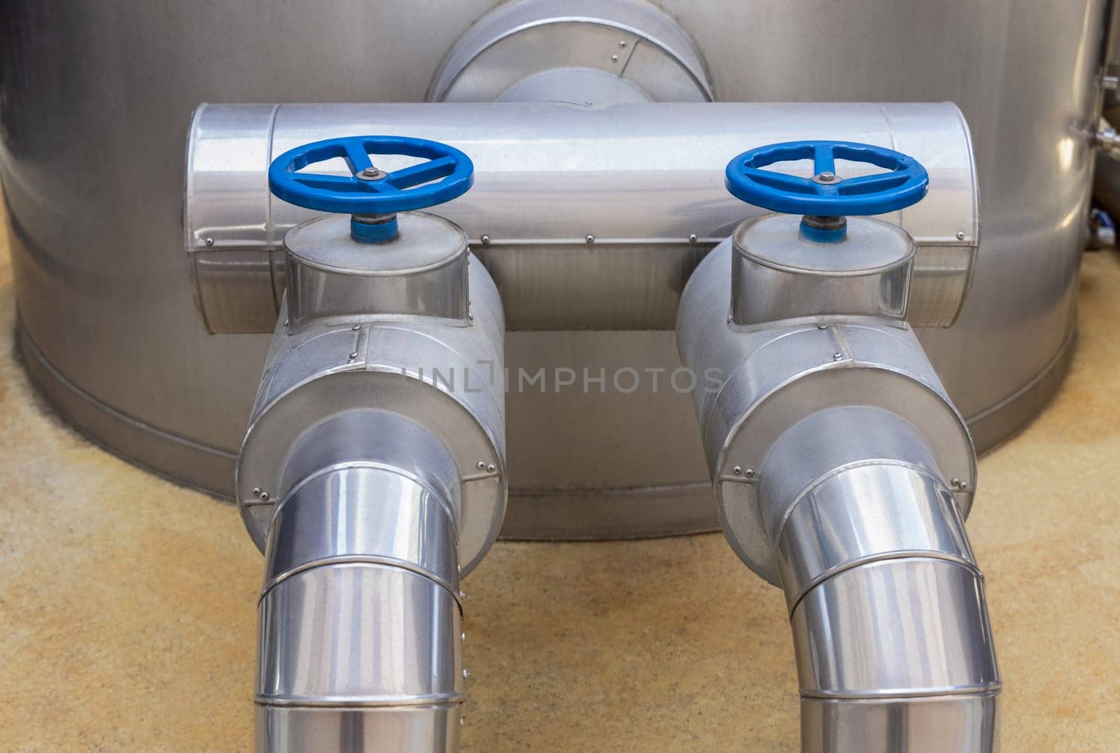 Handwheel type blue metal valves and pipes, industrial equipment at wine factory, close up, copy space
