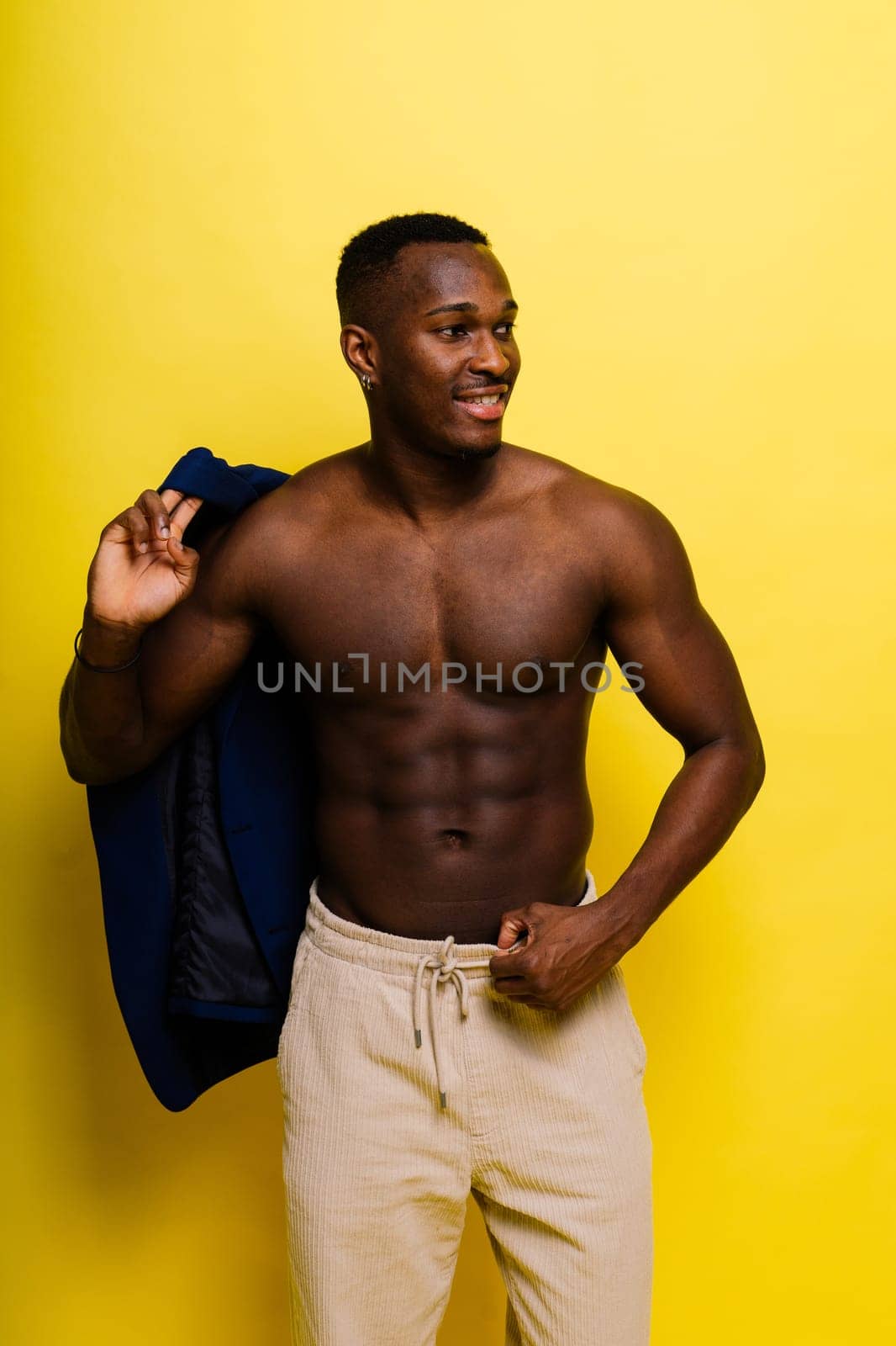 African black man model in a blue suit topless, studio background