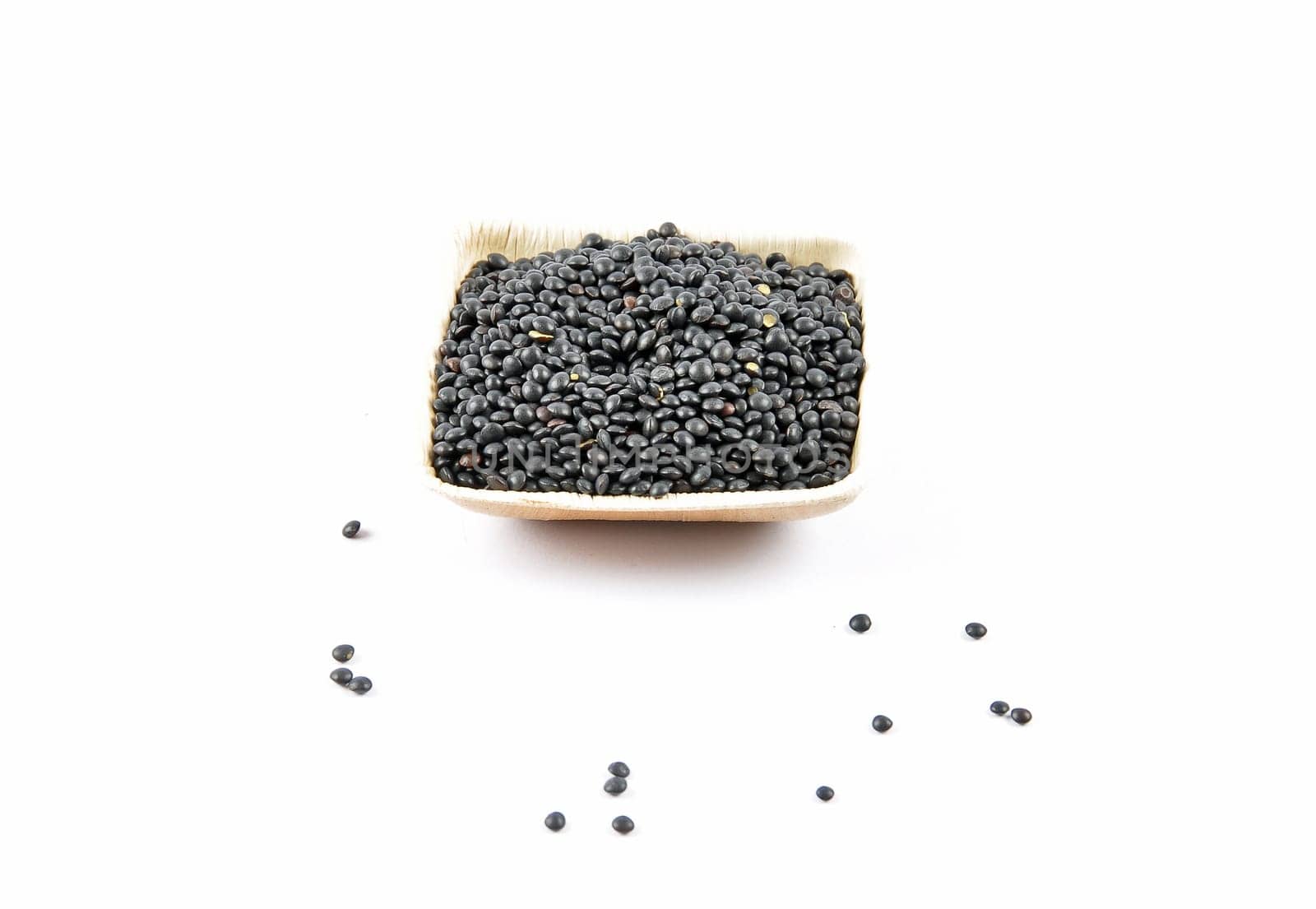 Beluga lentils in bamboo bowl on white background