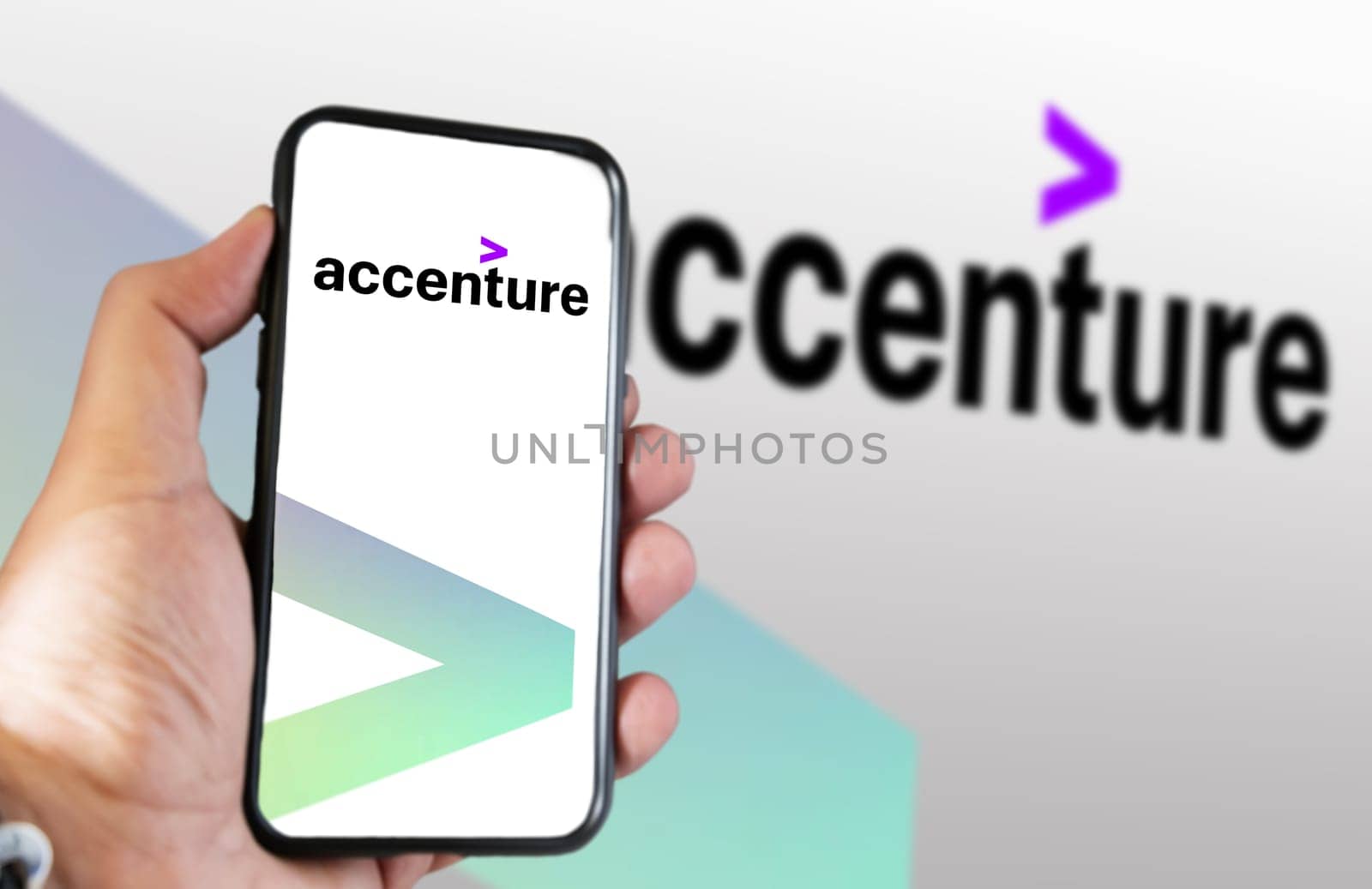 New York, US, March 2023: Hand holding a phone with Accenture logo displayed on the screen. Accenture is a multinational company that deals with business consulting. Illustrative editorial