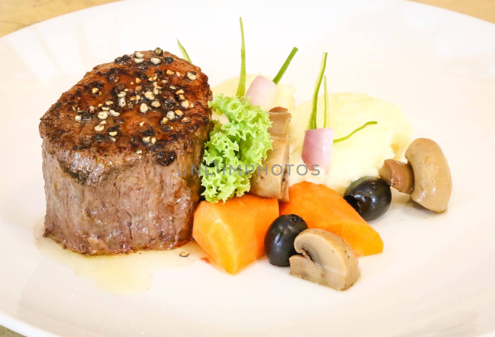 Tenderloin steak served with mashed potatoes and sauteed vegetables