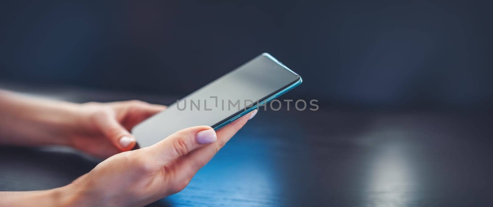 Woman indoors with mobile phone in her hands. Concept of businessperson and networking.