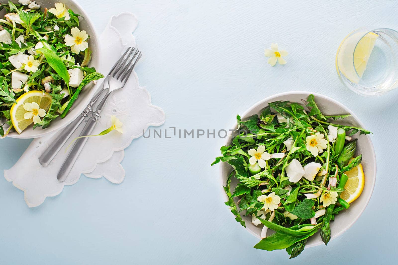 Spring salad with dandelion, asparagus, wild garlic, flowers, nettle and cream cheese. Healthy spring detox food ingredients.