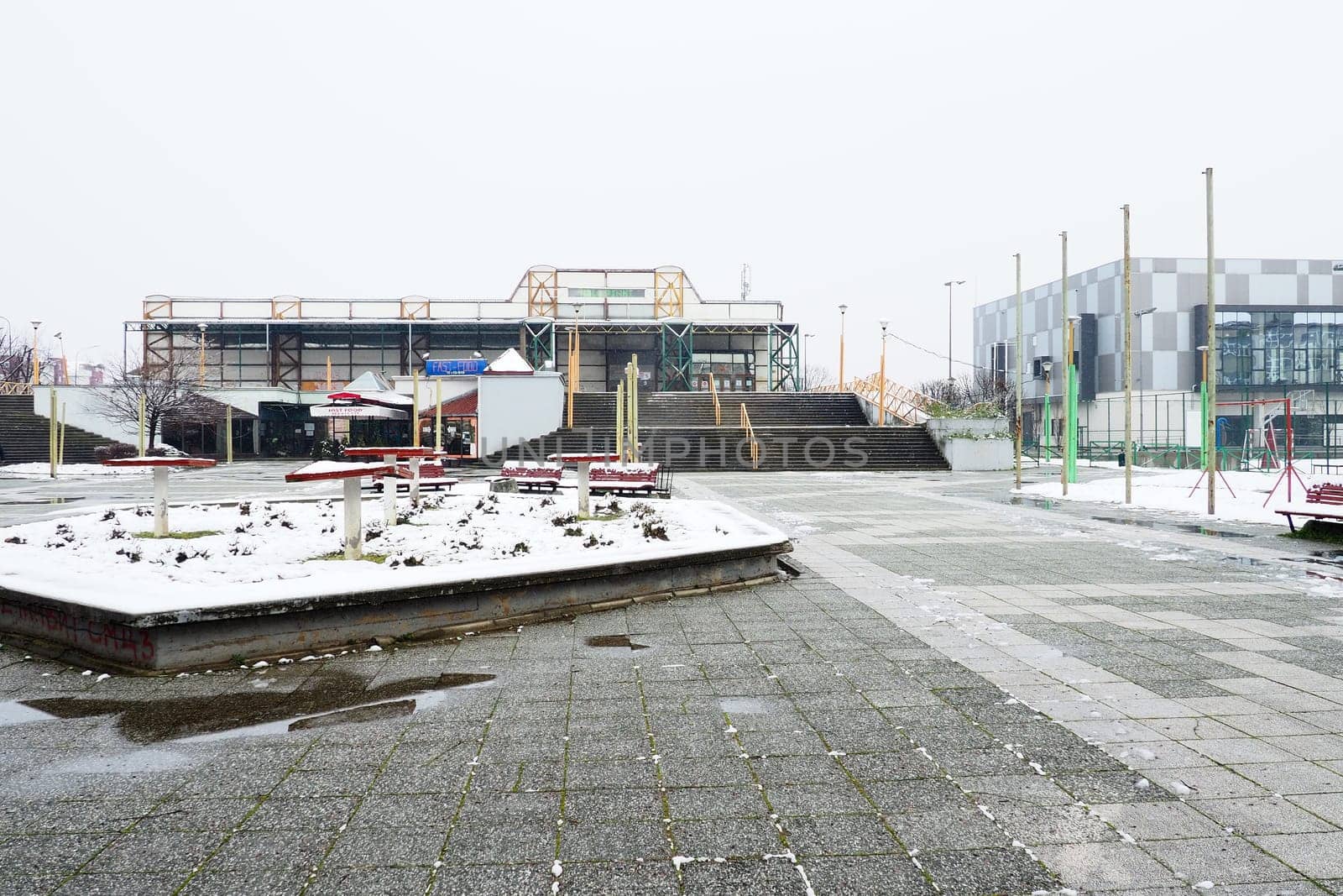 Sremska Mitrovica, Serbia January 27 2023 Pinky Swimming Pool and Pinky Sports Centre. Modern sports buildings, gray and white facade. Snow in winter. Venue for sporting events for adults and children