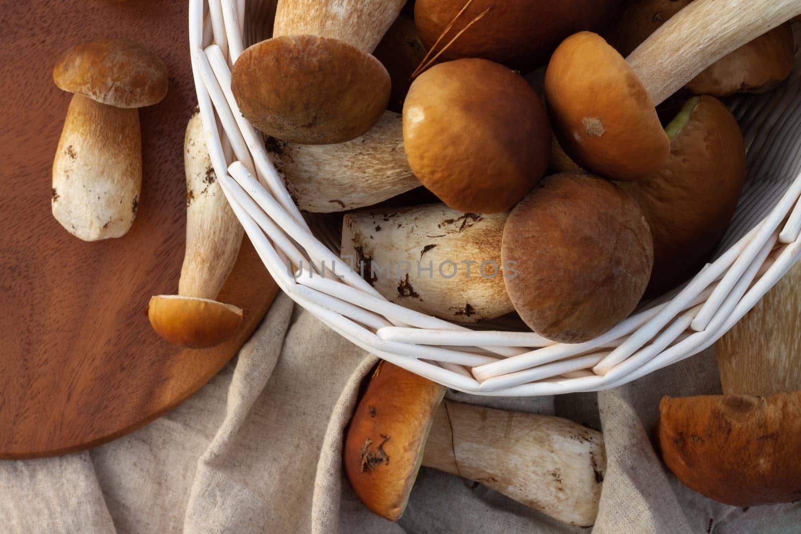 White wicker basket with boletus mushrooms. Top view.