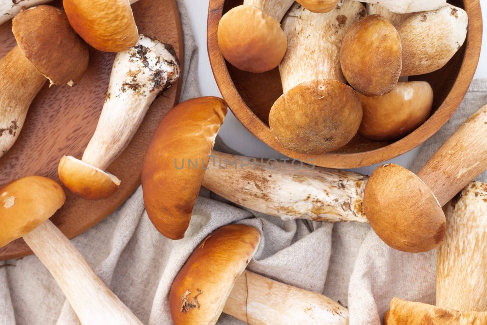 Brown boletus mushrooms on the background of a wooden tray. Top view.
