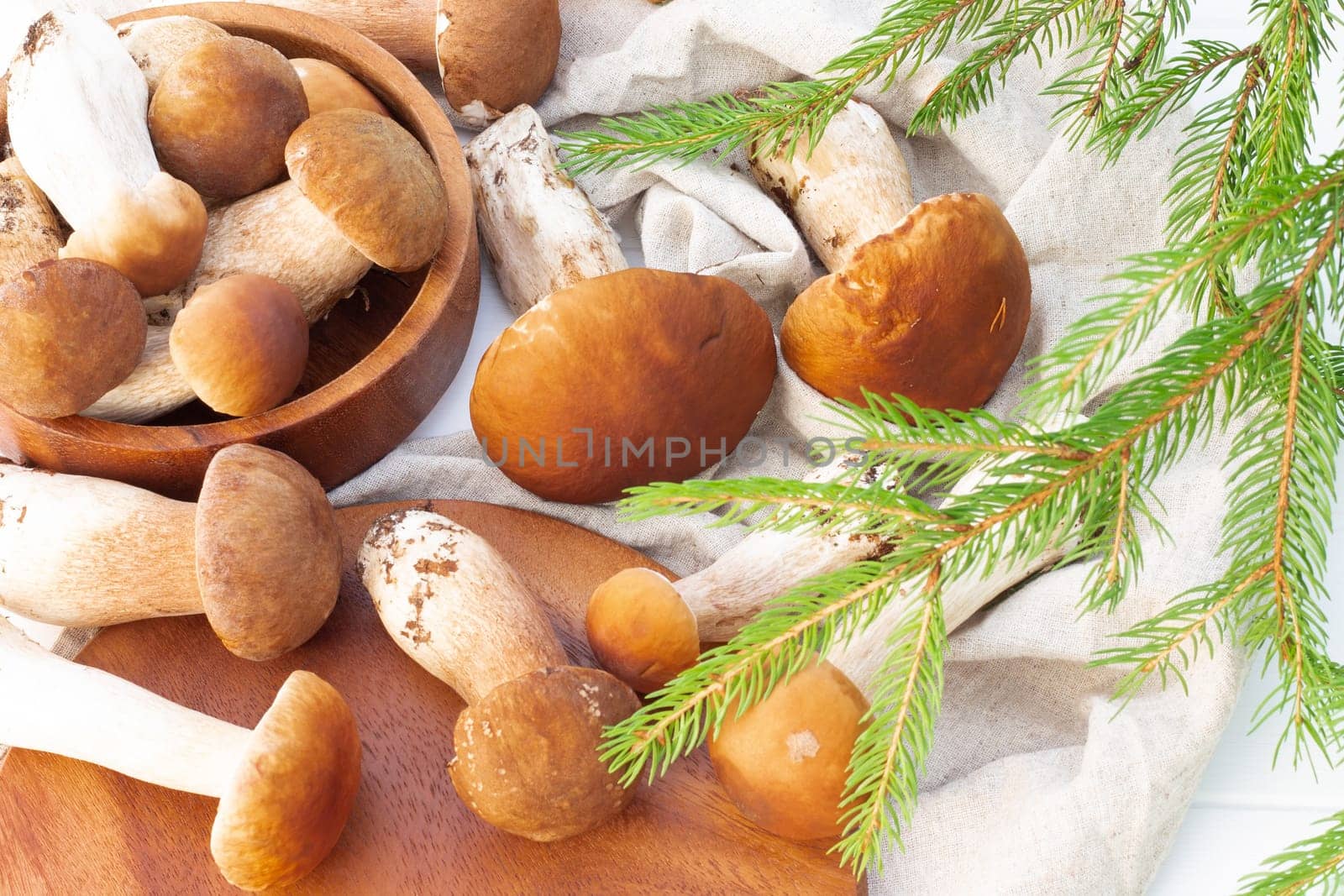 Brown boletus mushrooms on the background of a wooden tray. Top view.