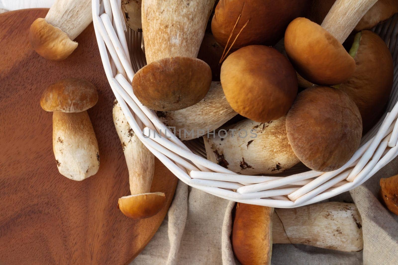 White wicker basket with boletus mushrooms. Top view.