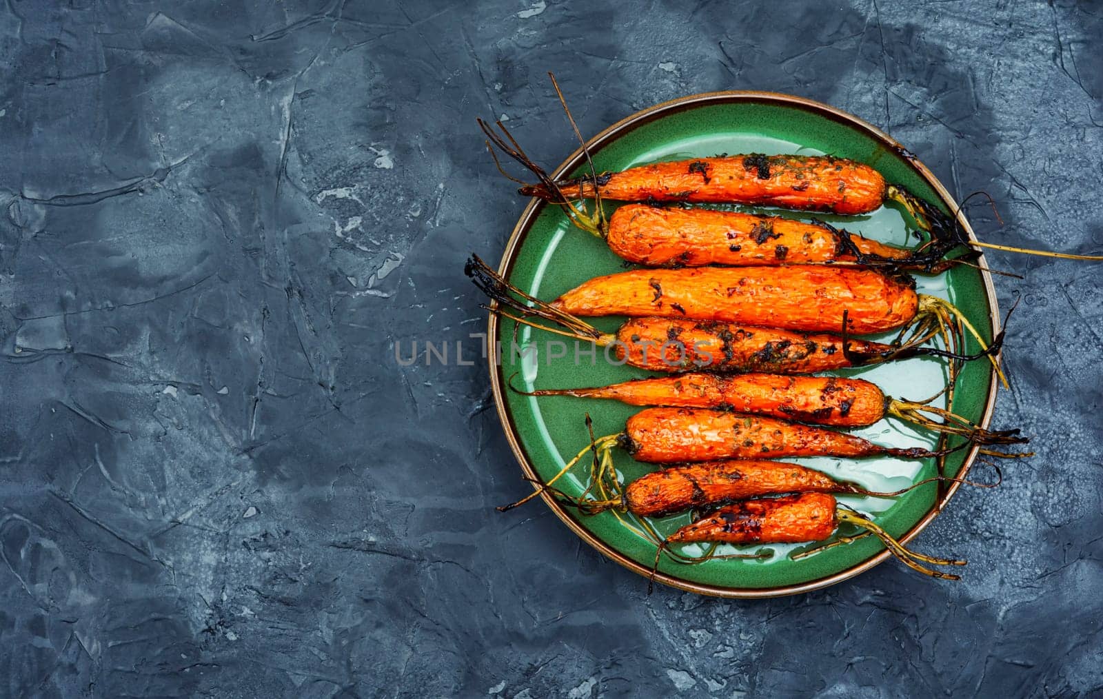 Roasted with herbs and spices whole carrots. Vegetarian healthy appetize.