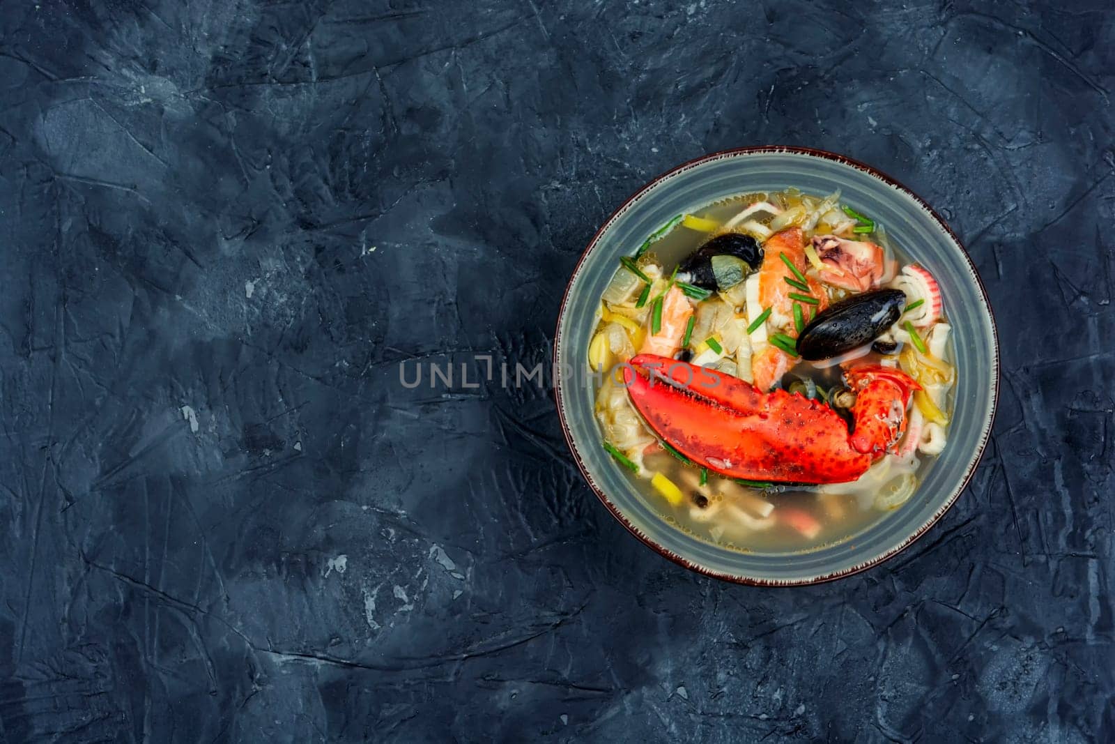 Fresh soup with lobster, mussels, shrimps and fish. Seafood soup. Space for text
