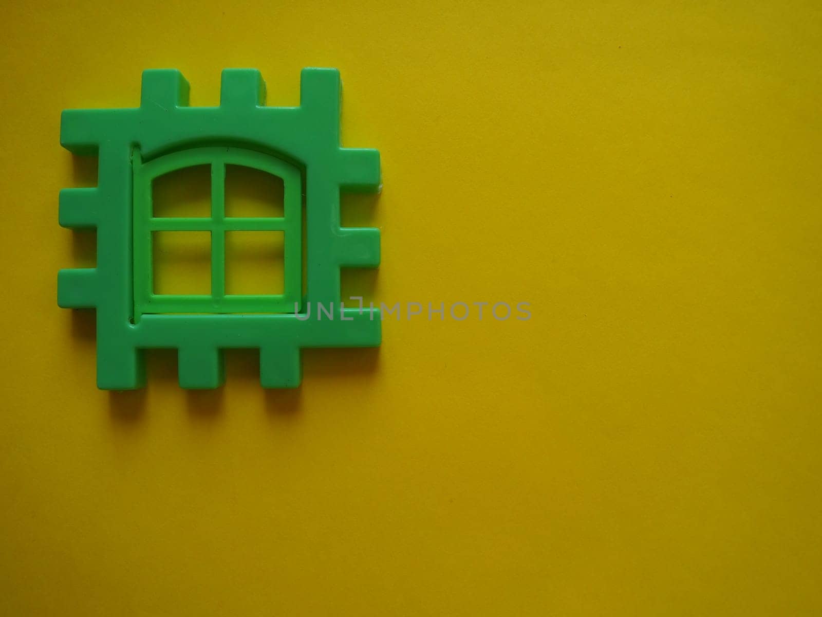 Multicolored plastic kids constructor on yellow background. Colored children's bricks for construction. Flat lay top view copy space. Plastic building blocks background. Developing toys, game