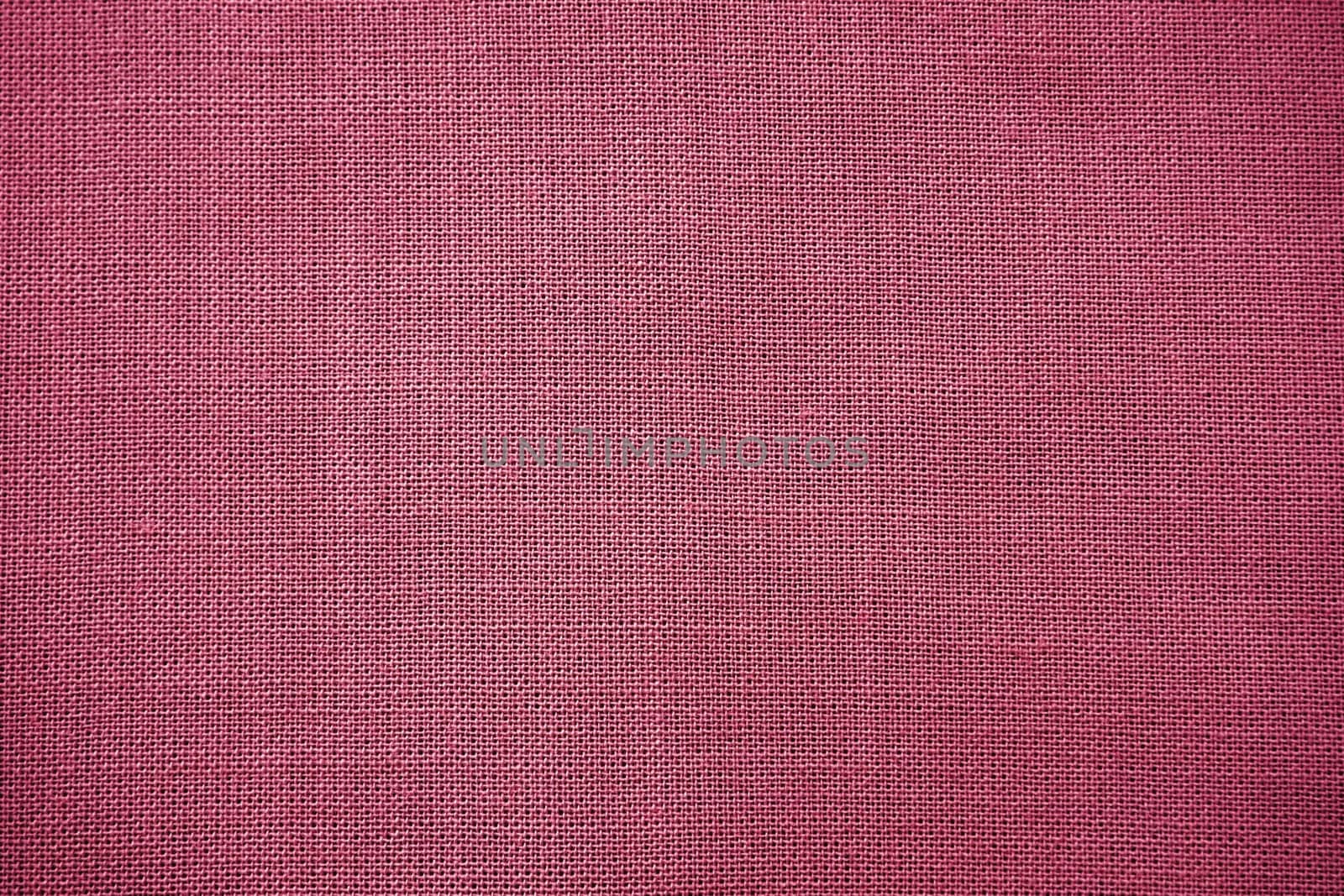 Cloth close-up. Interlacing of threads. A piece of pink fabric. Fabric background. Copy space.