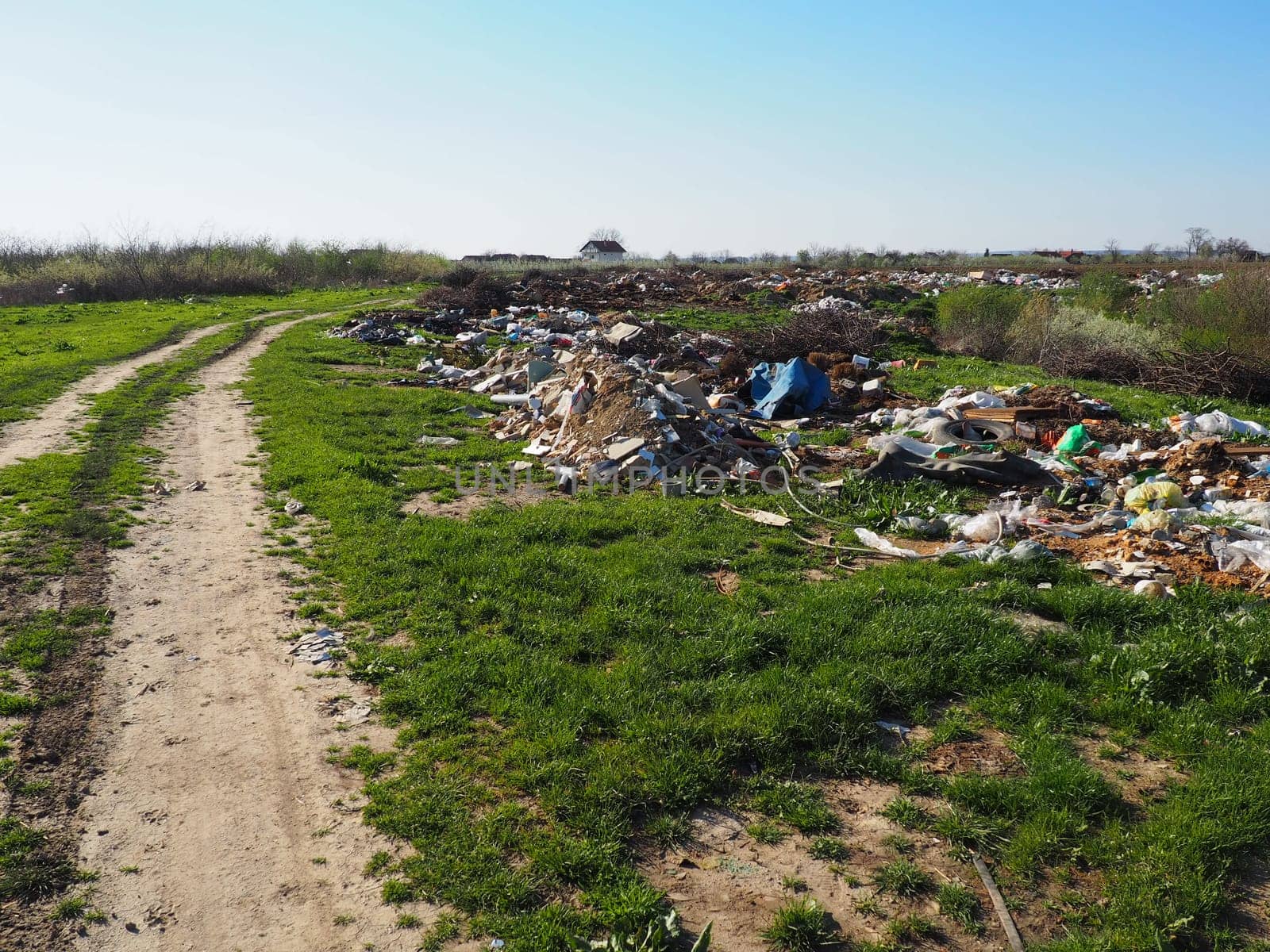 Sremska Mitrovica, Chalma, Serbia, 5 April 2021.garbage dump near the village. Chaotic unofficial dump. Plastic, bags, paper, glass, biological waste. Green grass next to dirt. Ecological catastrophy