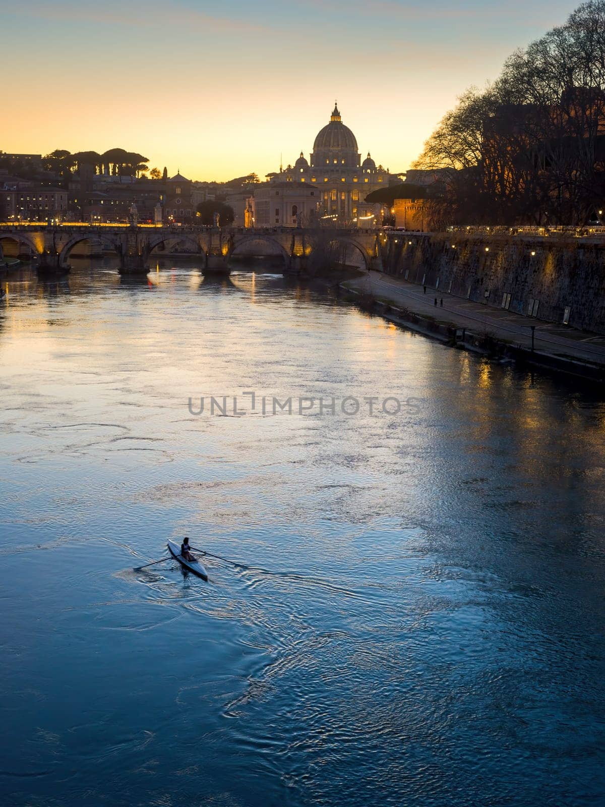 Evening view at the Angelo bridge and St. Peter's Basilica in Rome, Italy