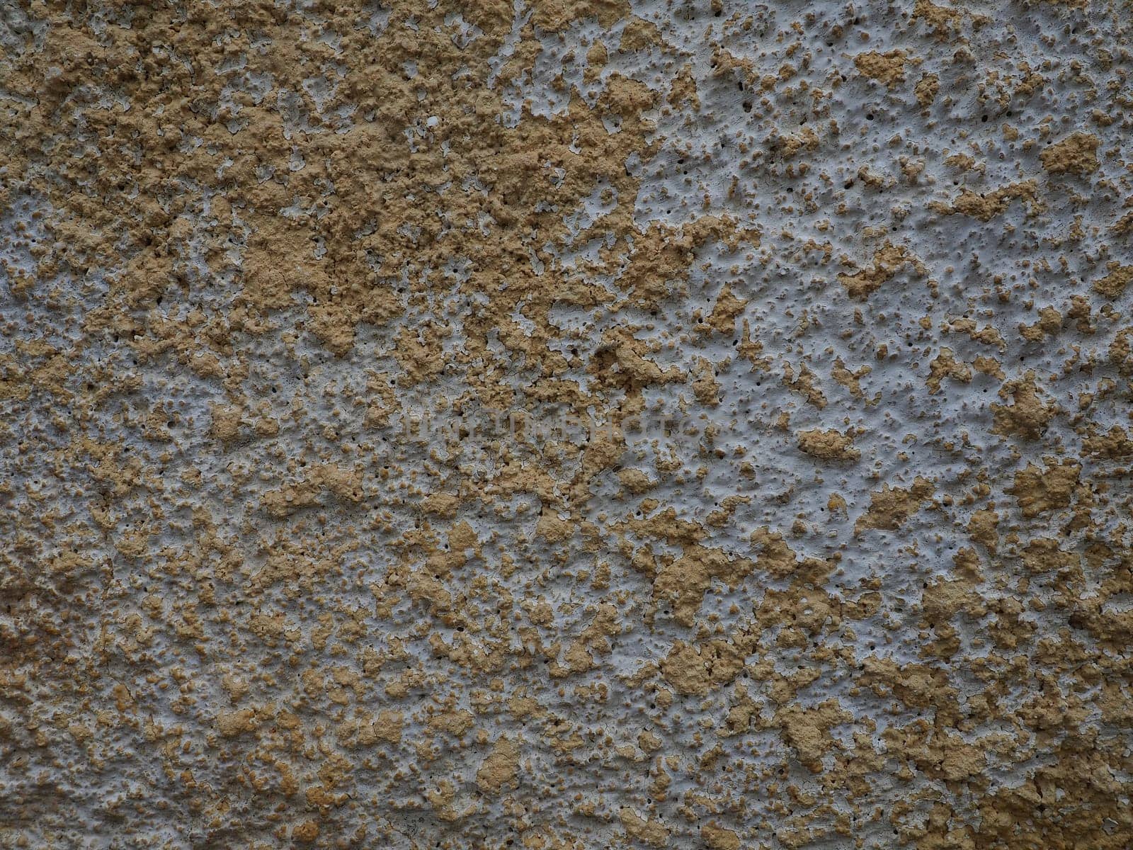 Concrete texture. Concrete wall with white and yellow paints. A casually painted wall. Grunge background with blank space. Copy space. Popcorn - plaster.