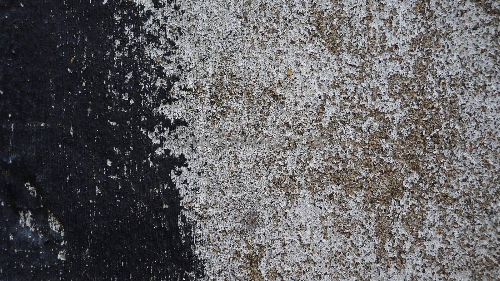 Concrete wall with black and white stripe of paint. Carelessly brushed parts, translucent gray plaster through the applied oil paint. Grunge background with empty space. Copy space.
