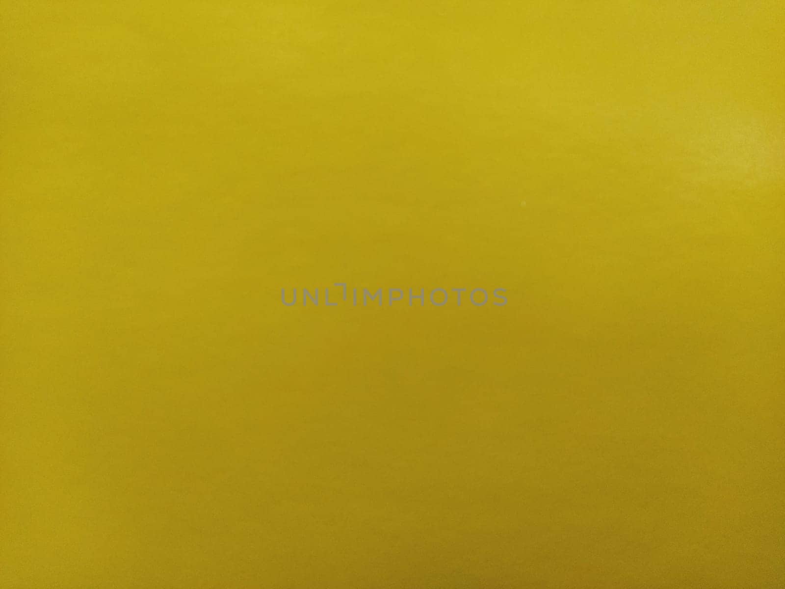 Nice yellow background. A sheet of paper close-up. Pure cheerful color. Vivid shade of yellow.