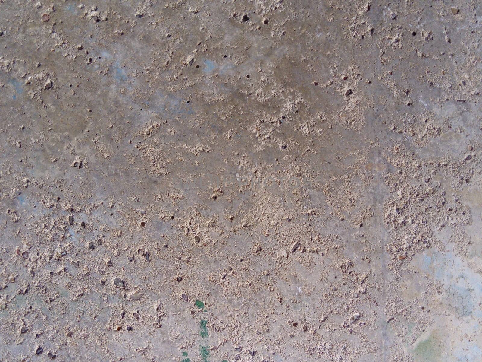 Concrete wall with concentric damage of large radius. Potholes, tubercles and defects. Gray, brown and beige colors. Planet surface concept. Concrete wall with a worn surface, potholes and stones