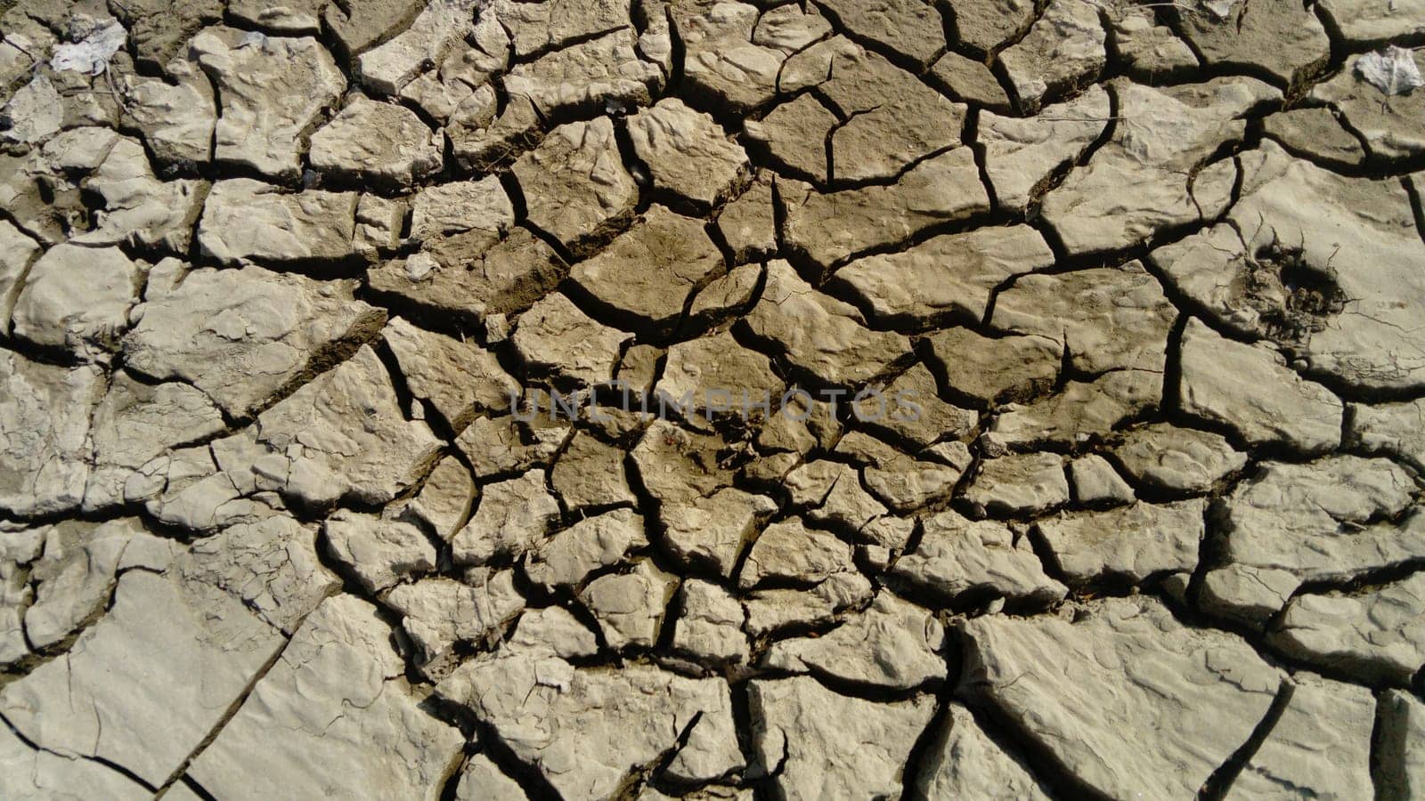 cracked clay soil due to drought and waste of river water. Red earth.