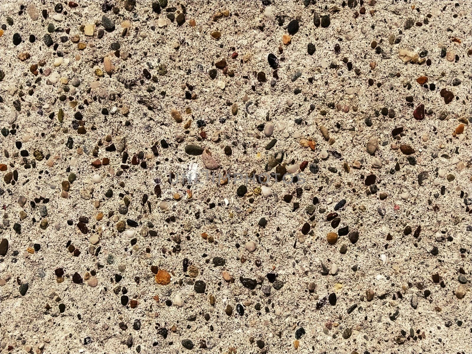 Granite smooth surface or slab in warm brown, gray, beige tones with frequent black spots and dots. Variant of interior decoration. Natural background. Stone cut