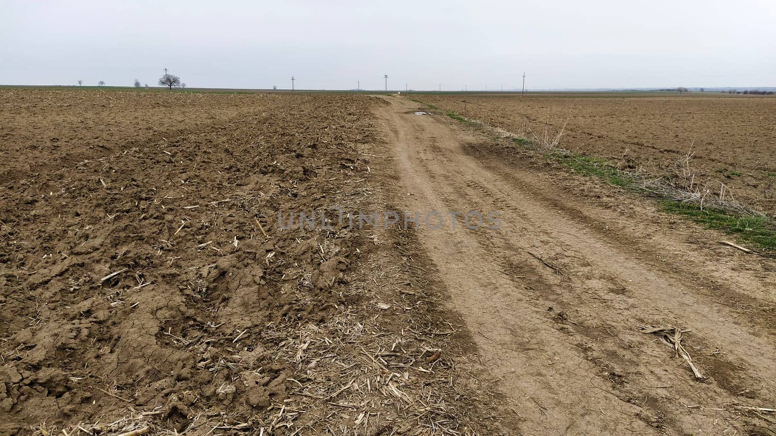 Freshly plowed field. Arable land with fertile soil for planting wheat. Rural landscape in Serbia, Balkans, namely Fruska Gora from Sremska Mitrovica. Furrows and pits. Preparatory agricultural work.