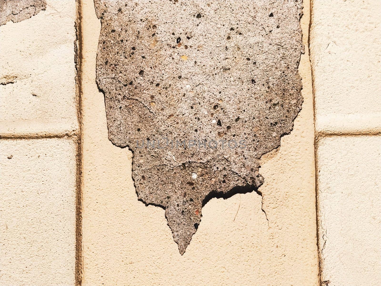 Plaster falling off the wall of a building. Facade condition in need of repair