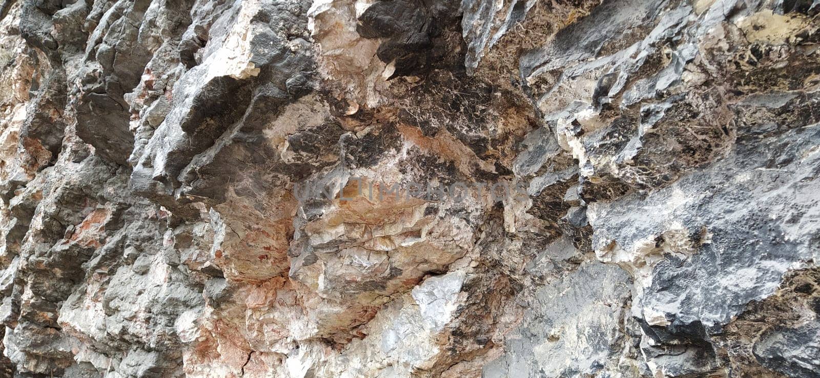stone rock closeup in Sarajevo, Bosnia and Herzegovina. Ancient frozen lava. Layers and strata of rocks. Mountain after a guided explosion to lay the road. Texture of the stone. Gray and beige colors.