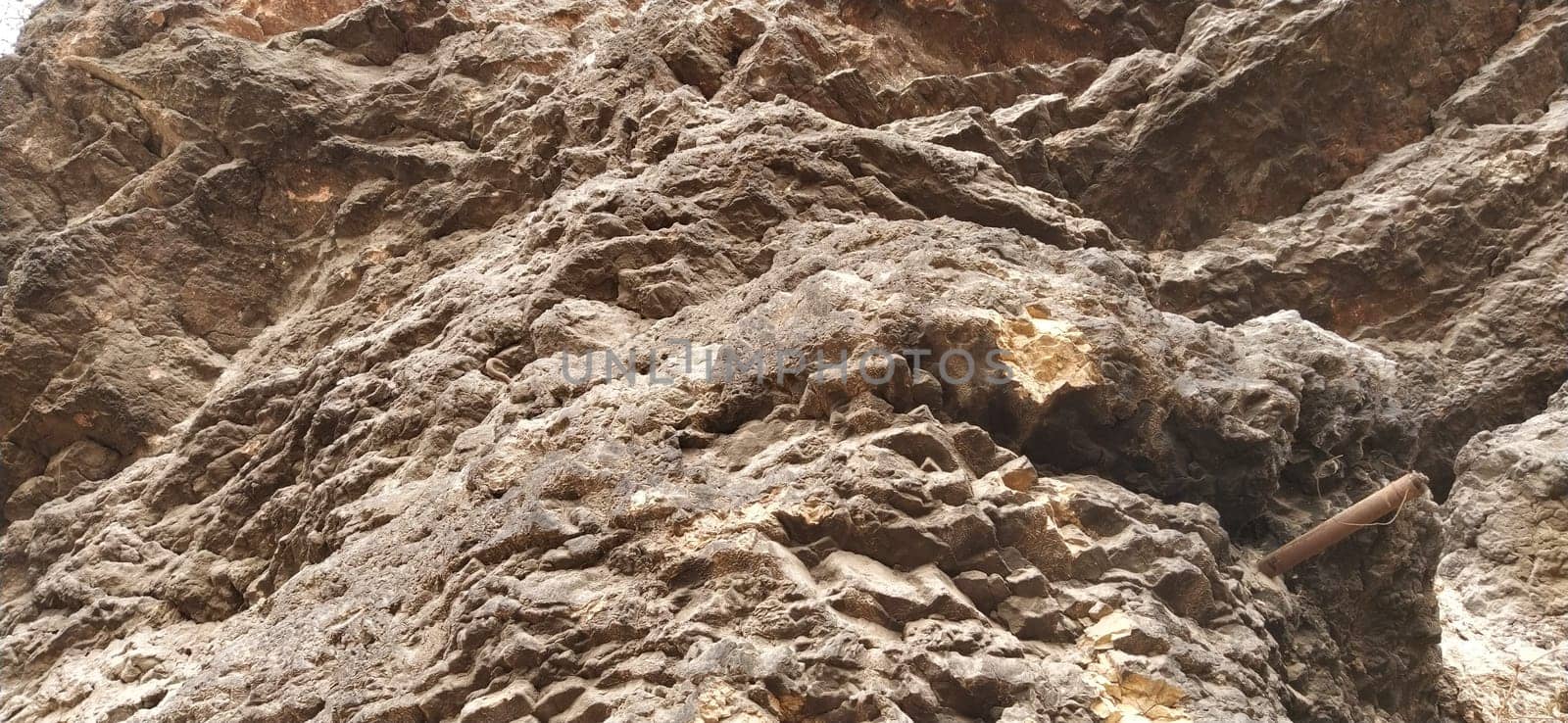 stone rock closeup. Sarajevo, Bosnia and Herzegovina. Ancient frozen lava. Layers and strata of rocks. Mountain after a guided explosion to lay the road. Texture of the stone. Gray and beige colors