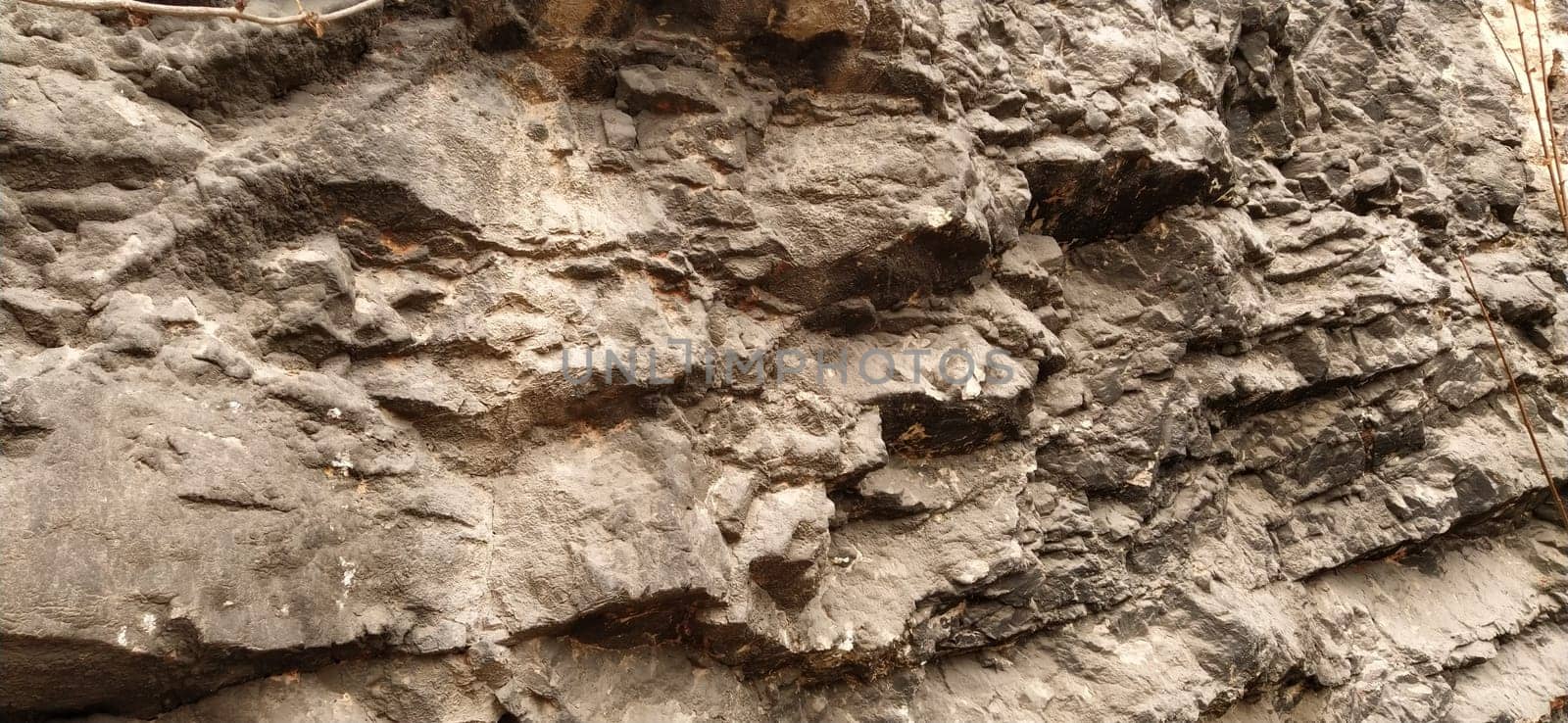 stone rock closeup in Sarajevo, Bosnia and Herzegovina. Ancient frozen lava. Layers and strata of rocks. Mountain after a guided explosion to lay the road. Texture of the stone. Gray and beige color.