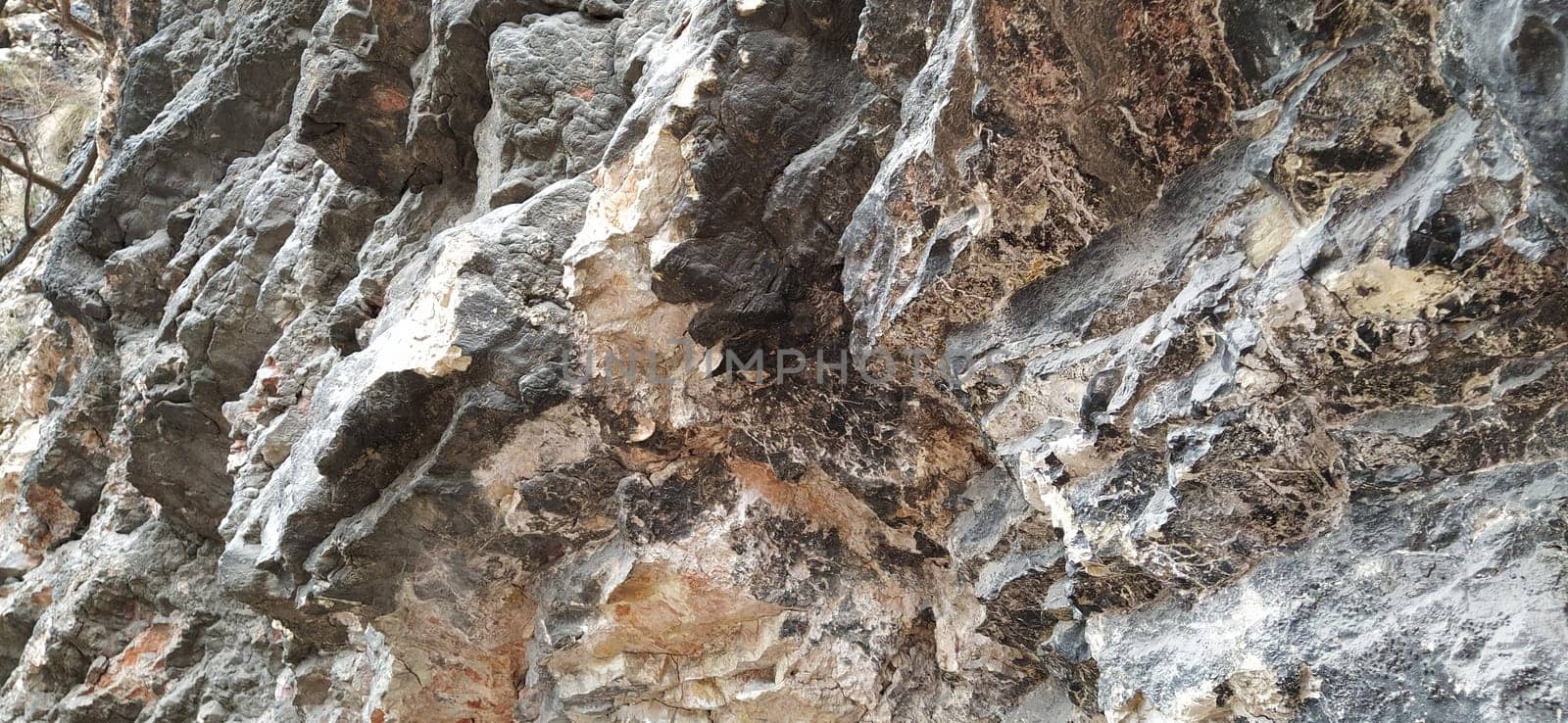 stone rock closeup in Sarajevo, Bosnia and Herzegovina. Ancient frozen lava. Layers and strata of rocks. Mountain after a guided explosion to lay the road. Texture of the stone. Gray and beige colors