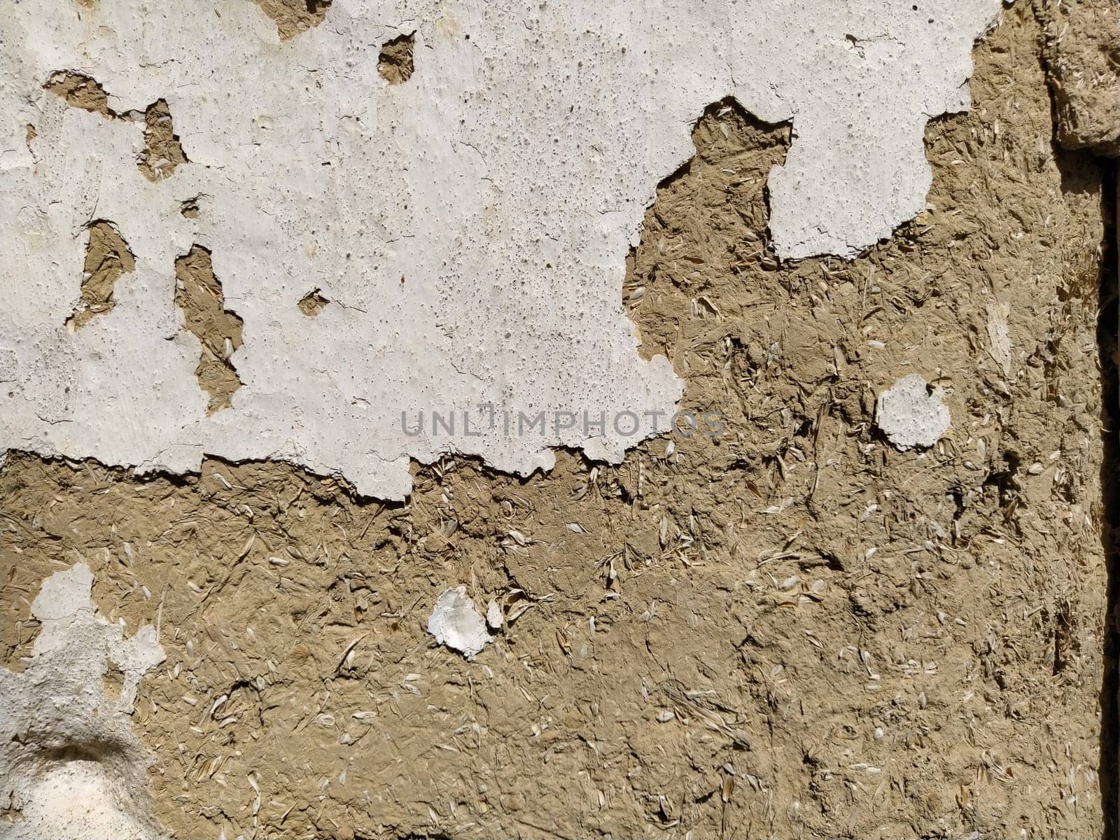 Close-up background of the wall of an old house made of clay mixed with straw. Old type of construction. Clay wall of straw and mud. Manure mixed with clay and dried as building material.