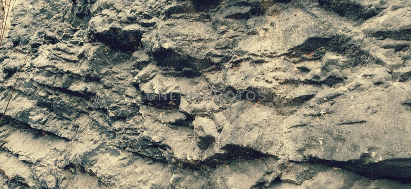Stone rock close up. Ancient frozen lava. Layers and strata of rocks. The texture of gray stone. Natural colors. Bosnia and Herzegovina, Sarajevo. Career development.