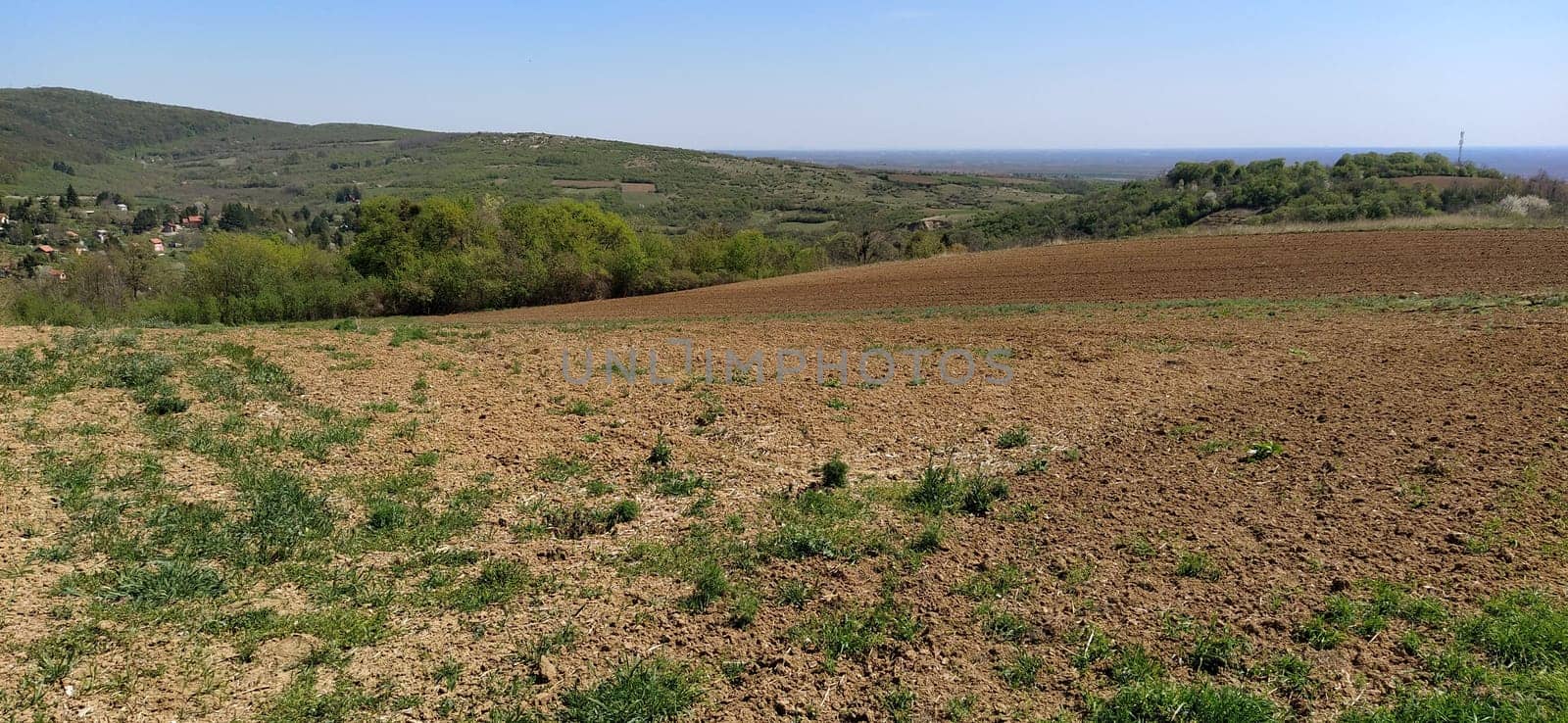 The slopes of the mountains with agricultural fields. Freshly plowed soil. Land cultivation and agricultural work. Fruska Gora, Serbia, Balkans.