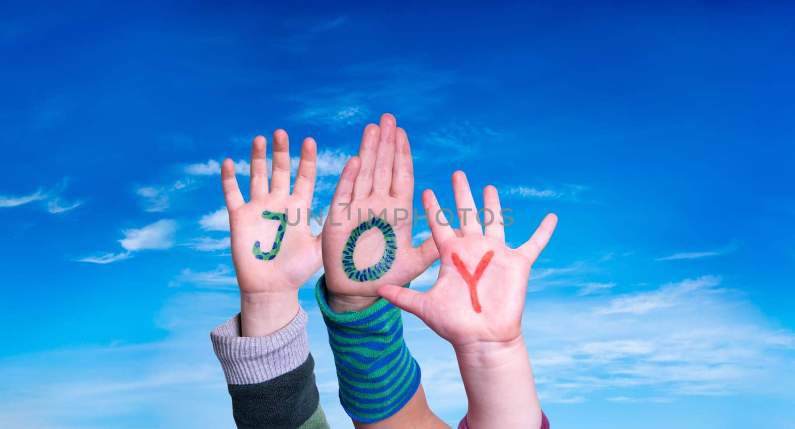 Children Hands Building Colorful English Word Joy. Blue Sky As Background
