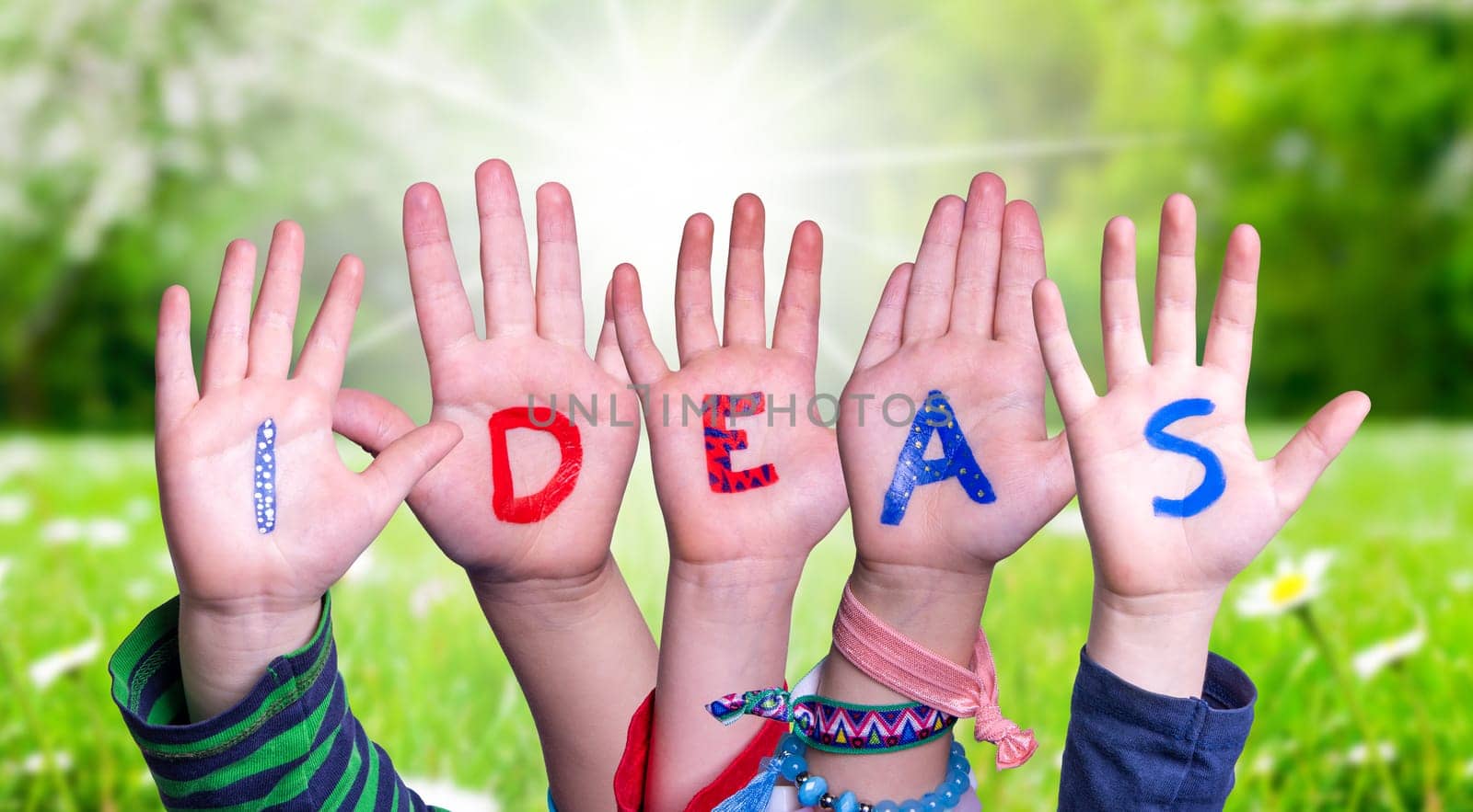 Children Hands Building Colorful English Word Ideas. Sunny Green Grass Meadow As Background.