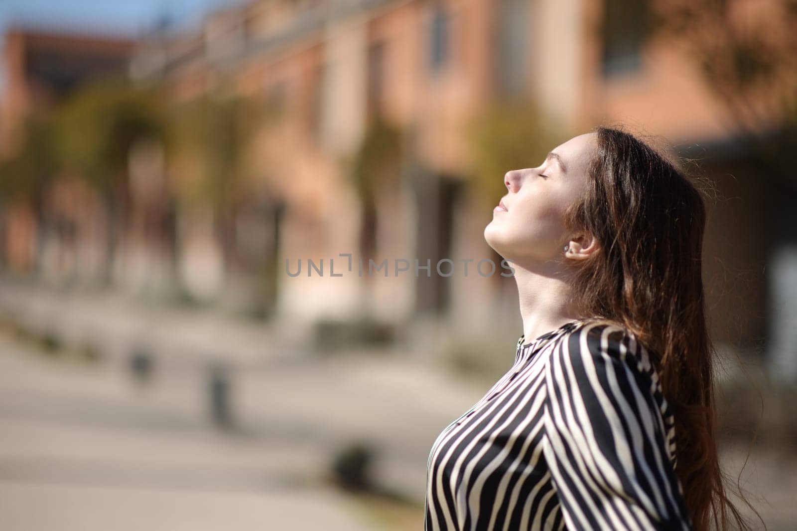 Profile of a woman breathing fresh air a sunny day in a residential area
